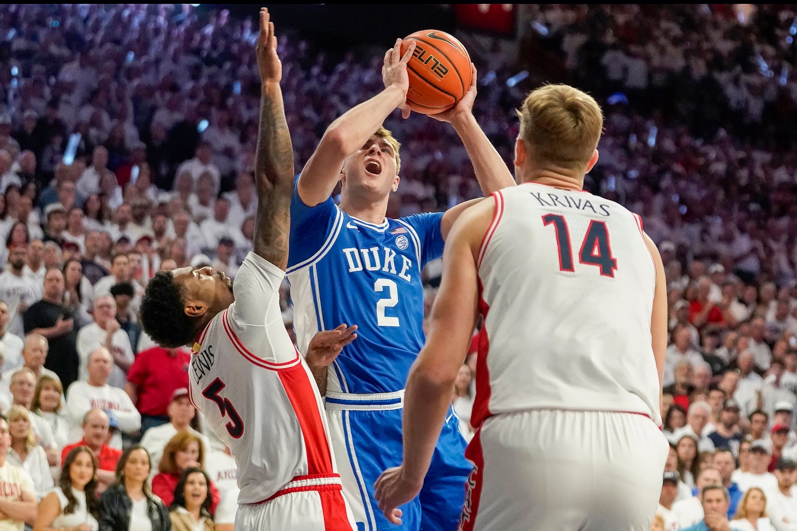 Duke guard Cooper Flagg (2) is double-teamed by Arizona guard KJ Lewis (5) and Motiejus Krivas (14) during the first half of an NCAA college basketball game Friday, Nov. 22, 2024, in Tucson, Ariz. (AP Photo/Darryl Webb)