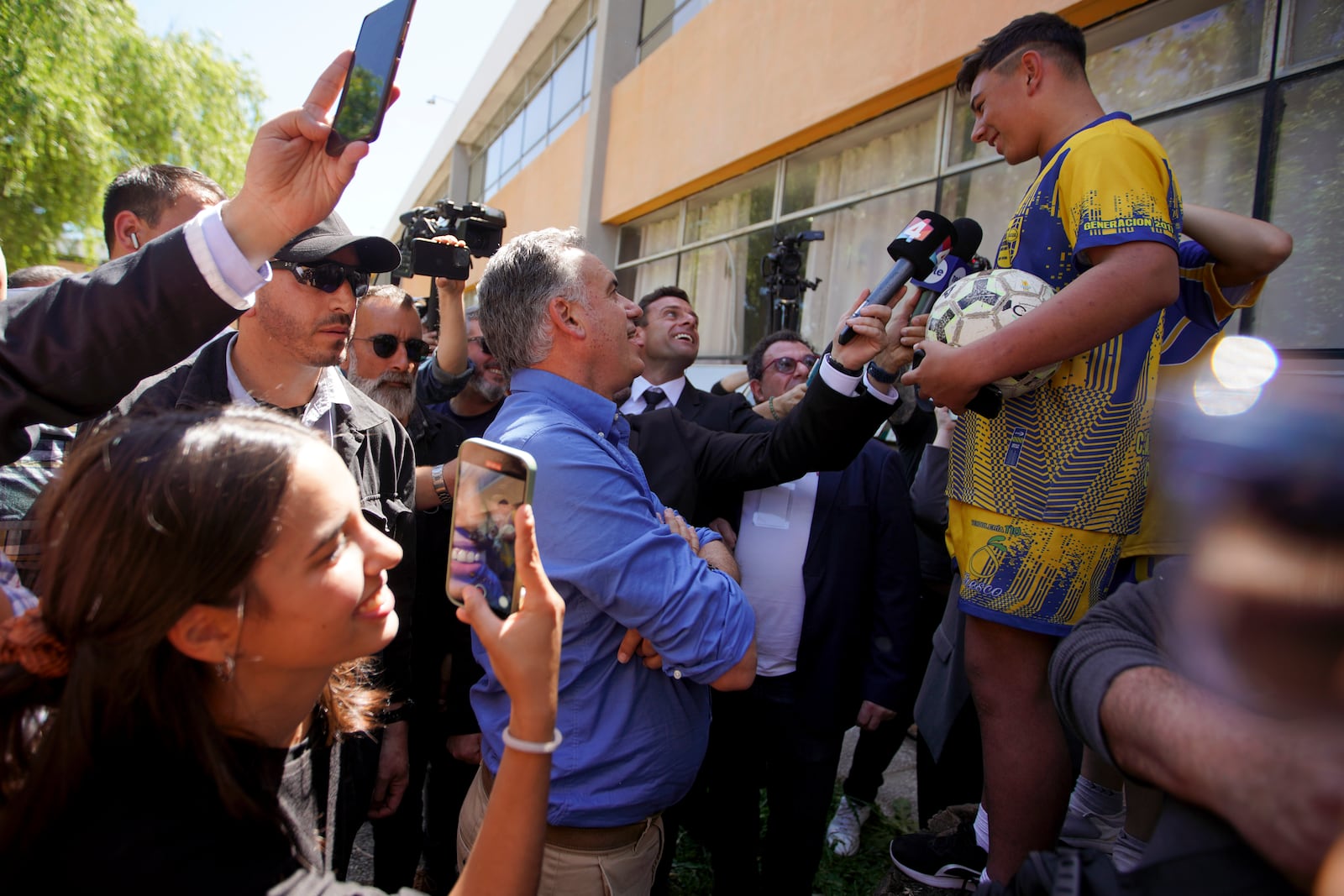 Frente Amplio presidential candidate Yamandu Orsi, center, talks to a youth after voting in general elections in Canelones, Uruguay, Sunday, Oct. 27, 2024. (AP Photo/Matilde Campodonico)