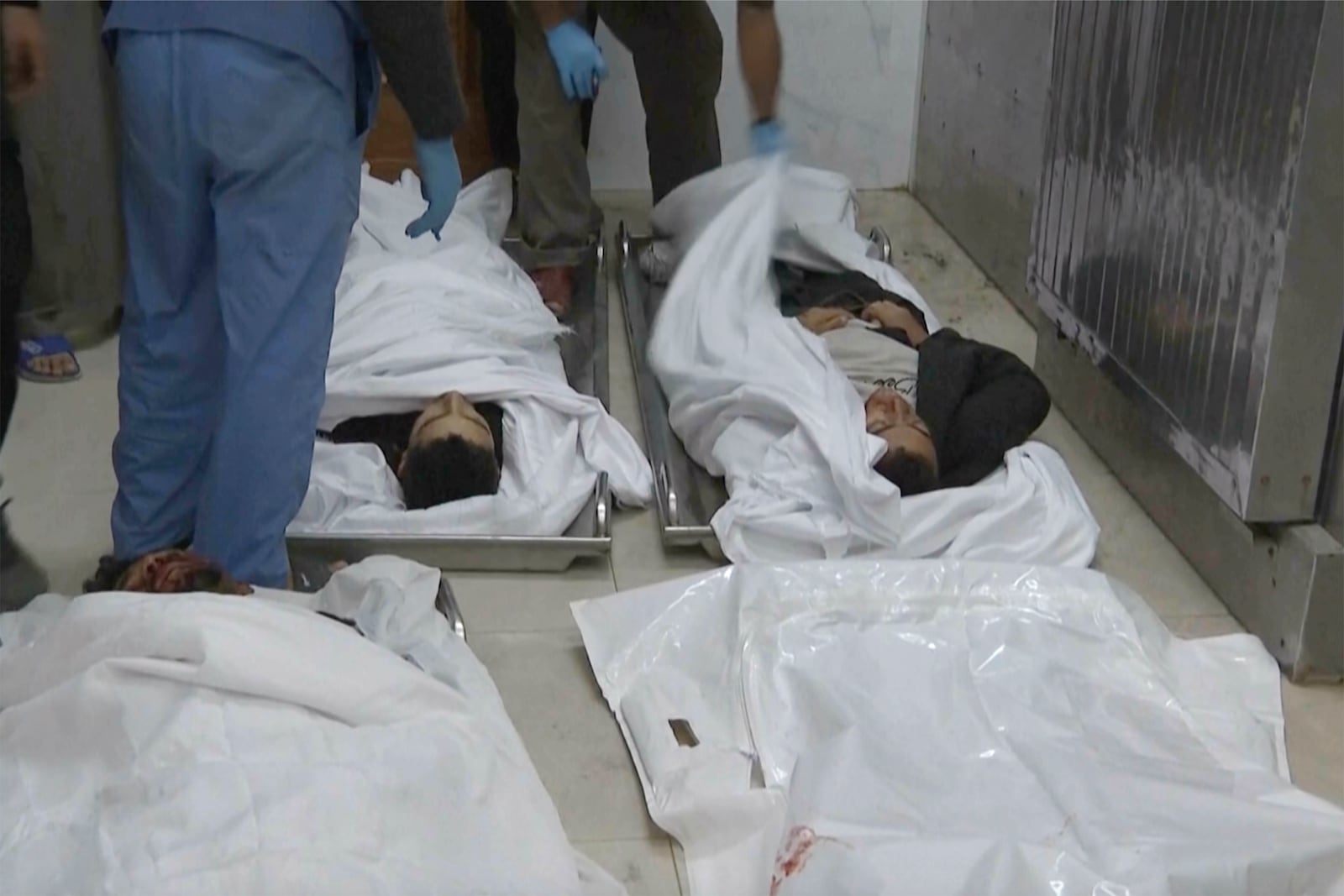 People stand near bodies on the ground inside the emergency department at Nasser hospital in Khan Younis after an Israeli airstrike on Saturday, Nov. 30, 2024. (AP Photo)