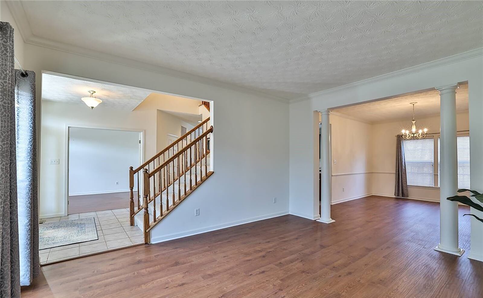 The entryway has a home office and formal living room on either side. Both have wide plank flooring that extends into the dining room and family room to the rear.