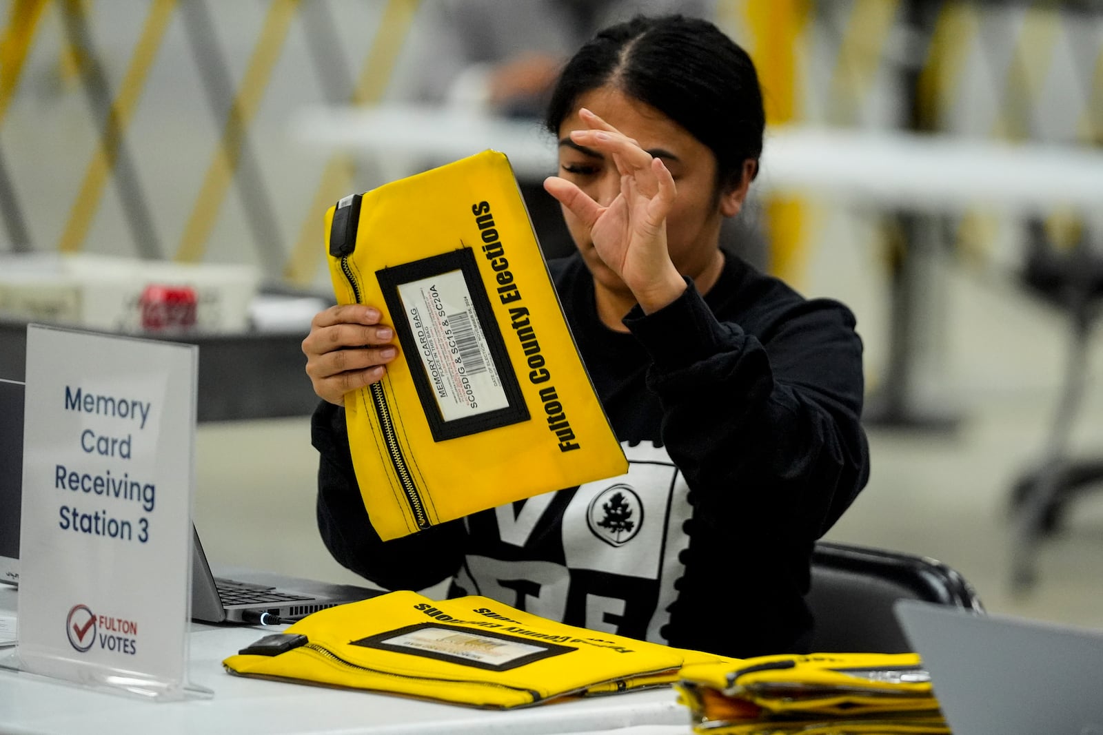 An election worker scans an envelope that holds a voting machine memory card at the Fulton County Election Hub and Operation Center, Tuesday, Nov. 5, 2024, in Atlanta. (AP Photo/John Bazemore)