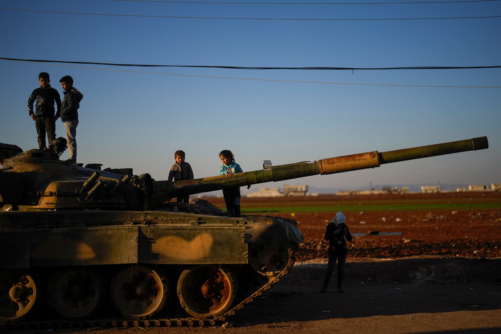 Children on the top of an ousted Syrian government forces tank that was left on a street in the town of Marea on the outskirts of Aleppo city, Syria, Tuesday, Jan. 28, 2025. (AP Photo/Khalil Hamra)