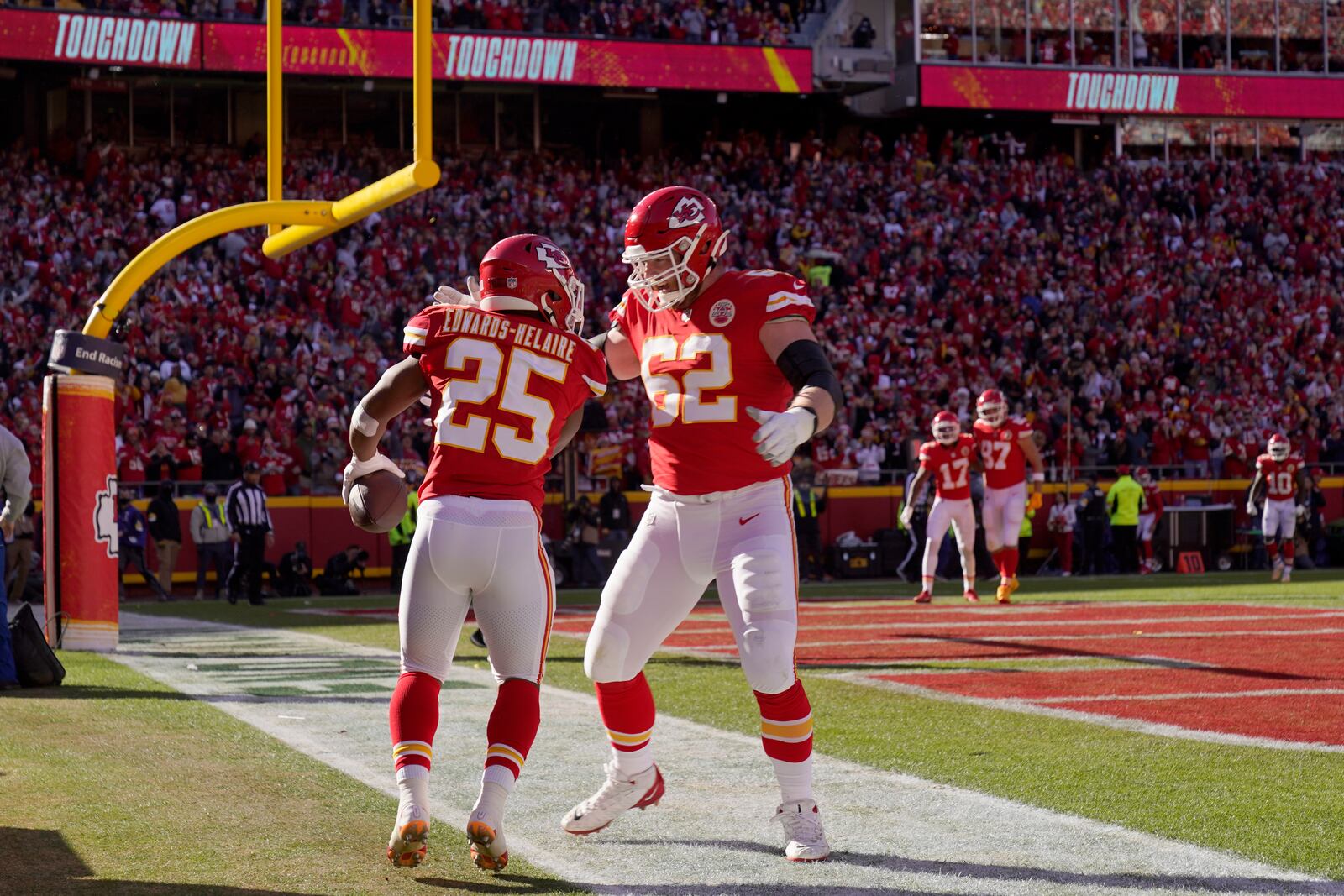 Kansas City Chiefs running back Clyde Edwards-Helaire (25) is congratulated by guard Joe Thuney (62) after scoring during the first half of an NFL football game against the Las Vegas Raiders Sunday, Dec. 12, 2021, in Kansas City, Mo. (AP Photo/Charlie Riedel)