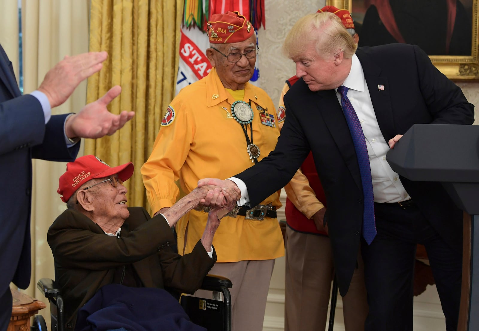 FILE - President Donald Trump meets with Navajo Code Talkers, Fleming Begaye Sr., seated and Thomas Begay, center, in the Oval Office of the White House in Washington, Nov. 27, 2017. (AP Photo/Susan Walsh, File)