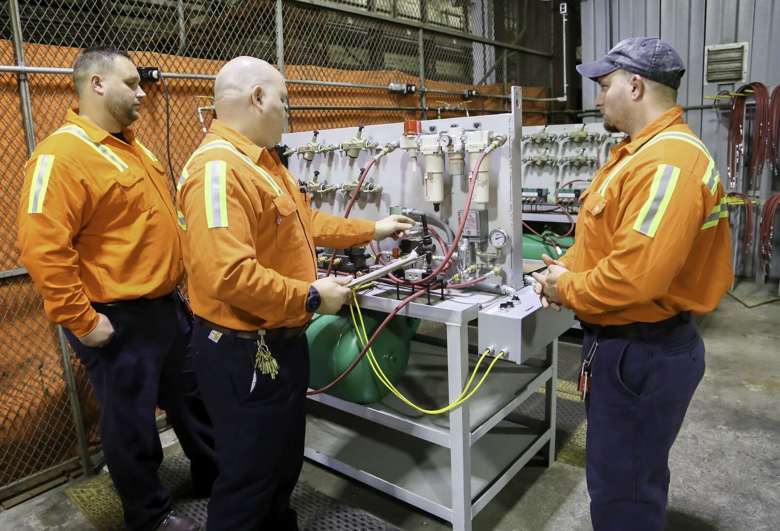 Chad Johnson, Fluid Power Instructor, center, works with apprentices Tony Adams and John Campbell as part of their new Maintenance Mechanic Apprenticeship Program, Friday, Oct. 5, 2018. 