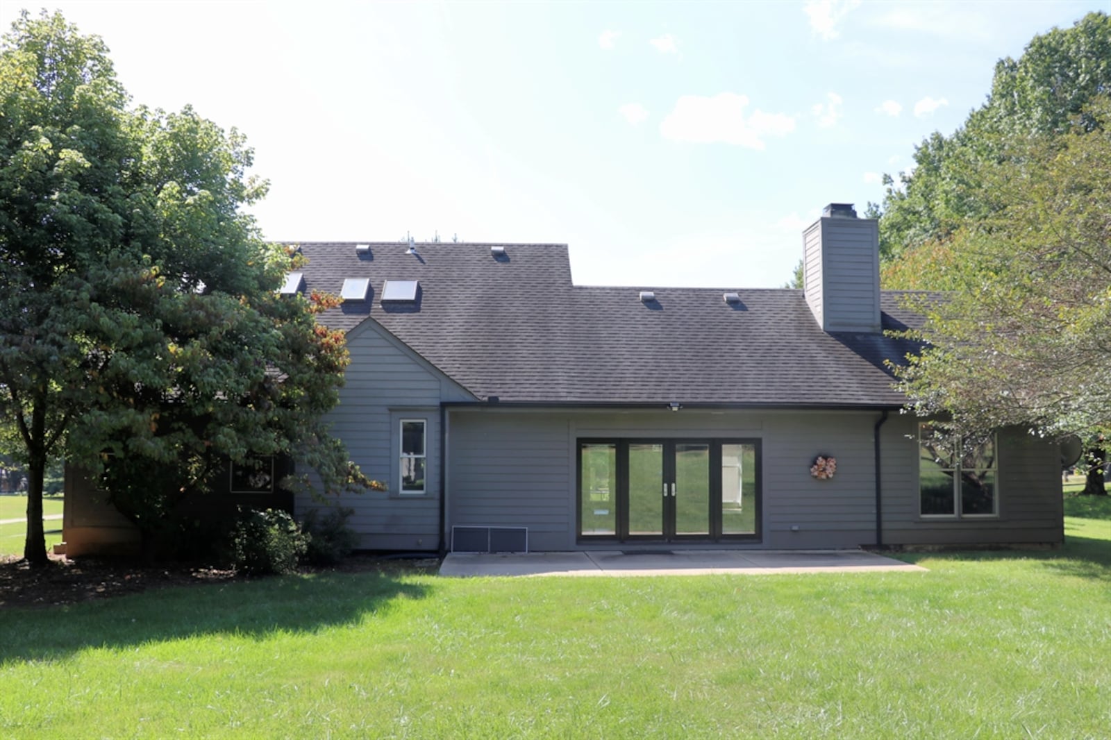 Mature trees provide a backdrop to the backyard. Tucked among the trees are a garden shed and a pergola sitting area. 