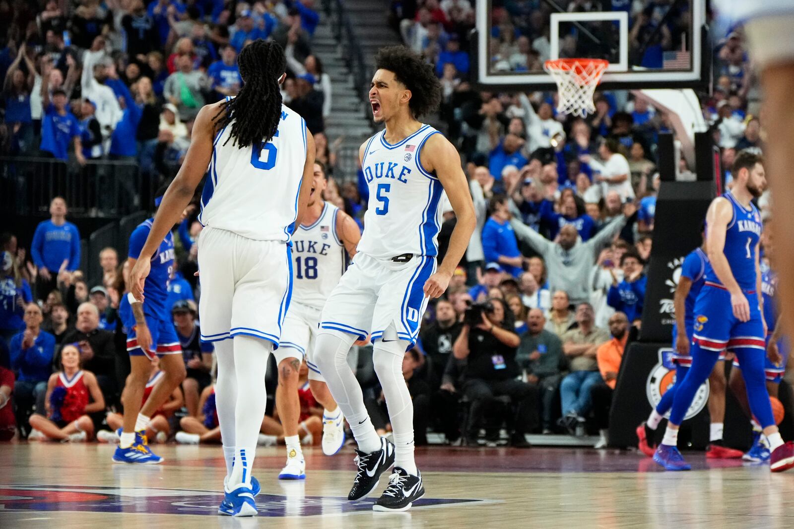 Duke guard Tyrese Proctor (5) reacts with forward Maliq Brown (6) after making a play against Kansas during the first half of an NCAA college basketball game Tuesday, Nov. 26, 2024, in Las Vegas. (AP Photo/Lucas Peltier)