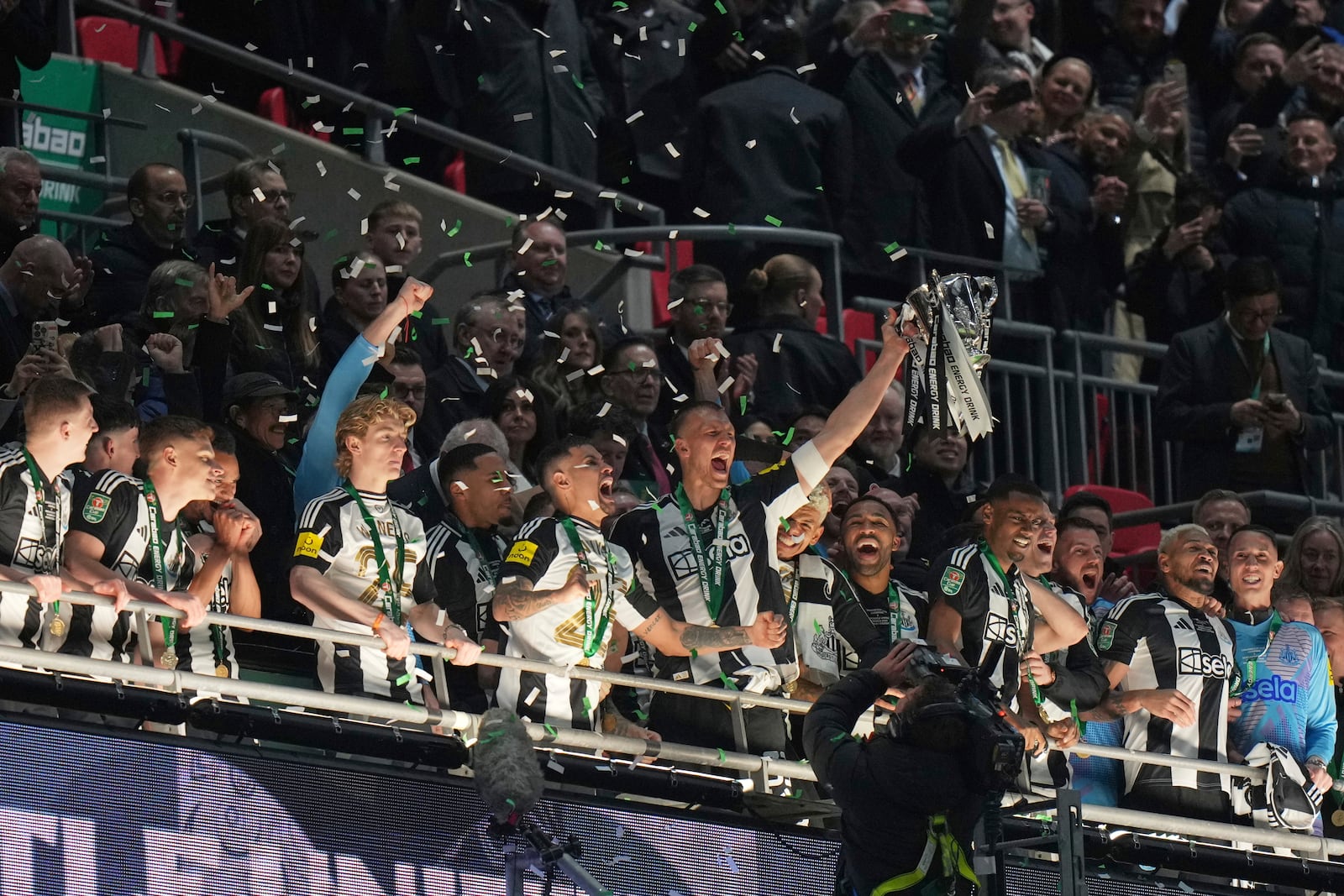 Newcastle United players celebrate with the trophy after winning the EFL Cup final soccer match between Liverpool and Newcastle at Wembley Stadium in London, Sunday, March 16, 2025. (AP Photo/Alastair Grant)