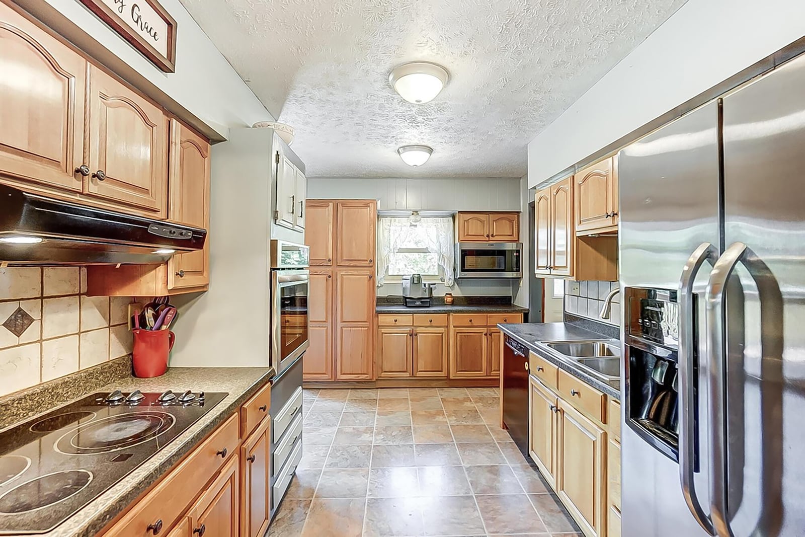 The kitchen has wood cabinets, tile flooring and updated appliances.