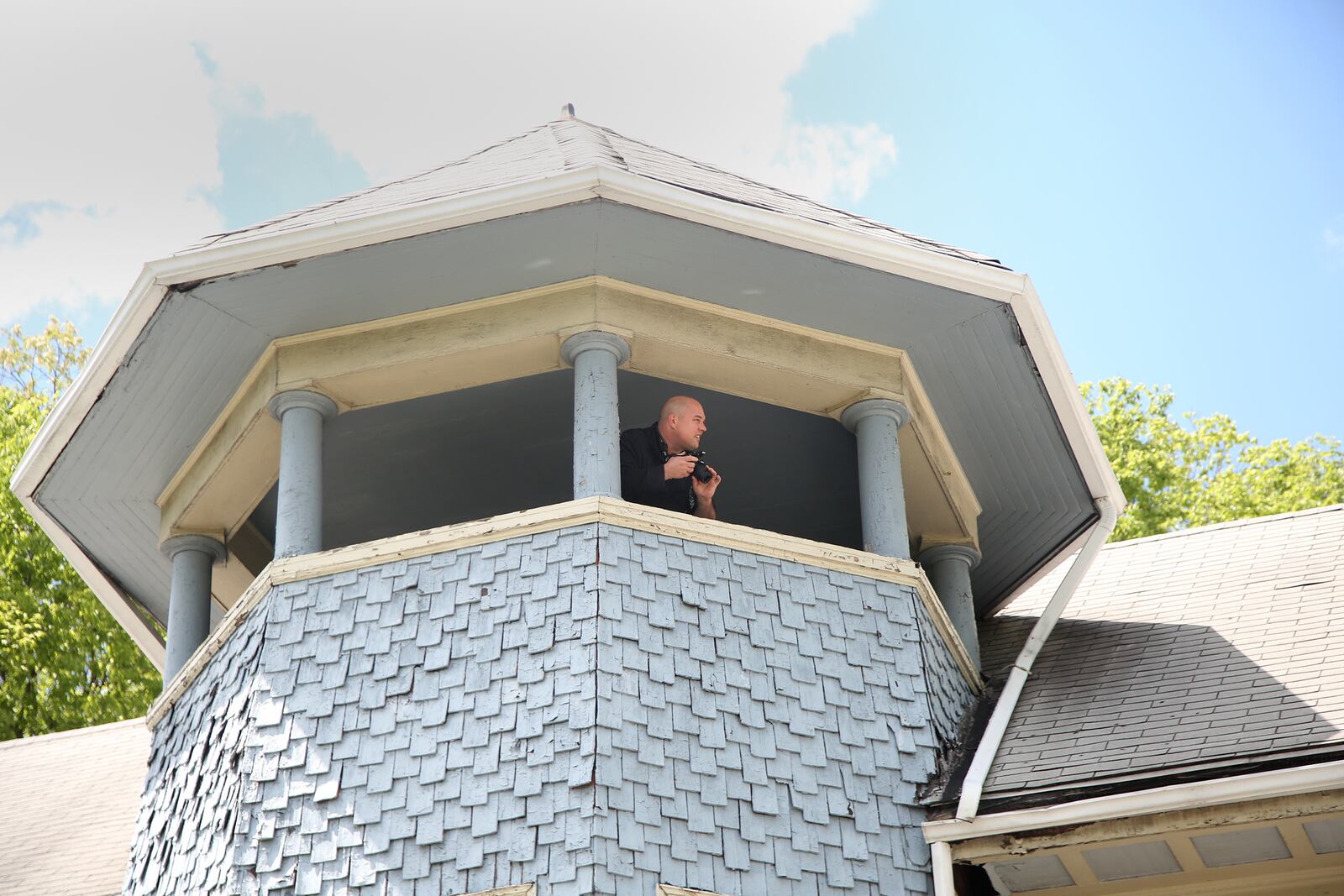 Jason Antkoviak of Beavercreek inspects the polygonal tower of a historic home in the Dayton View Historic District known as the Cox Mansion. The owner of the home is unable to preserve the home and plans to give it away to someone who can. Antkoviak and 29 others were among a group of people interested in saving the house who were given an interior tour. LISA POWELL / STAFF