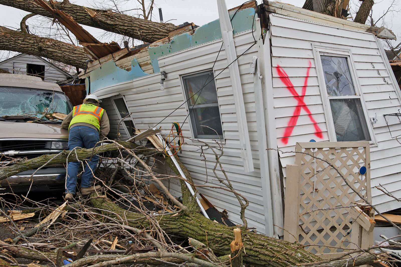 A utility worker checks for a gas shut off on a destroyed home in Russells Point Friday, March 15, 2024. BILL LACKEY/STAFF