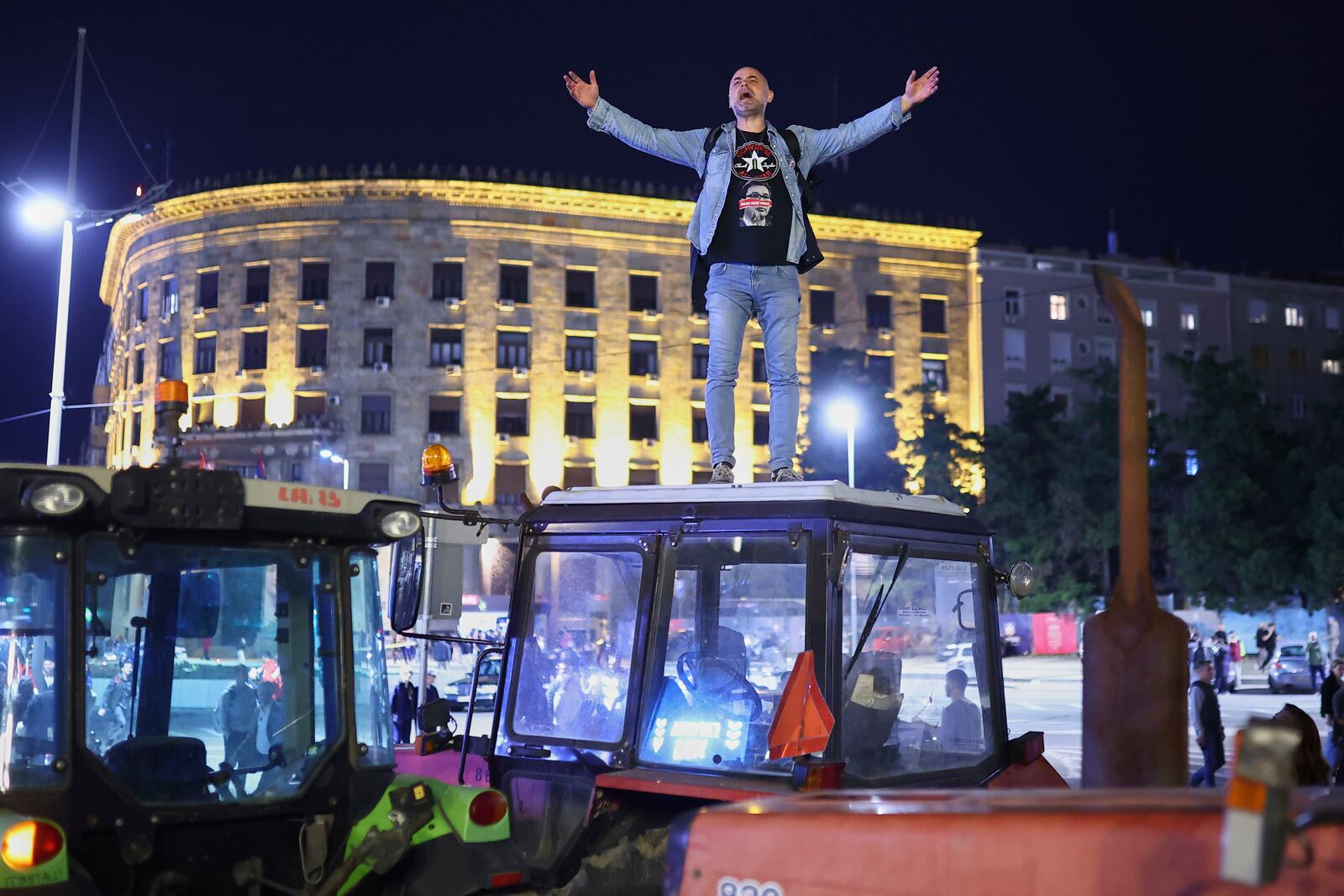 A protester yells from the top of a tractor ahead of a major rally this weekend in downtown Belgrade, Serbia, Friday, March 14, 2025. (AP Photo/Armin Durgut)