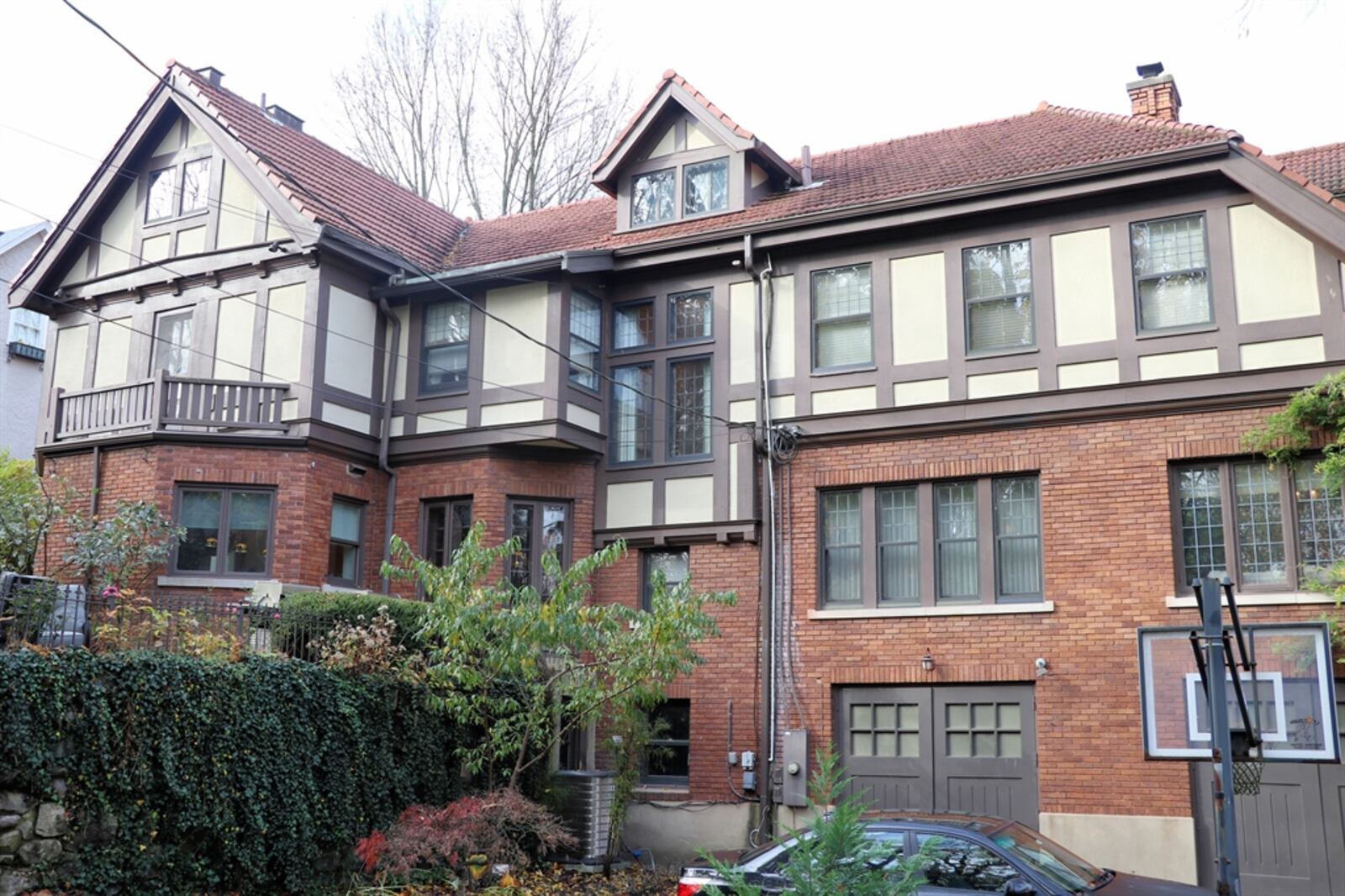 An electric gate opens to a terrace backyard with an upper-level paver-brick patio and garden and a lower-level greenspace play area, as well as a paved patio with access to the two-car carriage garage. 