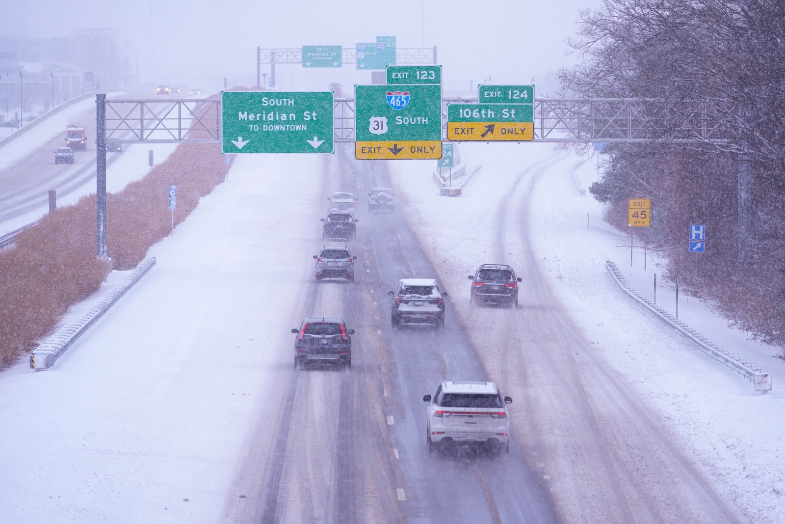 Traffic makes it way on snow-covered U.S. 31 in Carmel, Ind., Monday, Jan. 6, 2025. (AP Photo/Michael Conroy)