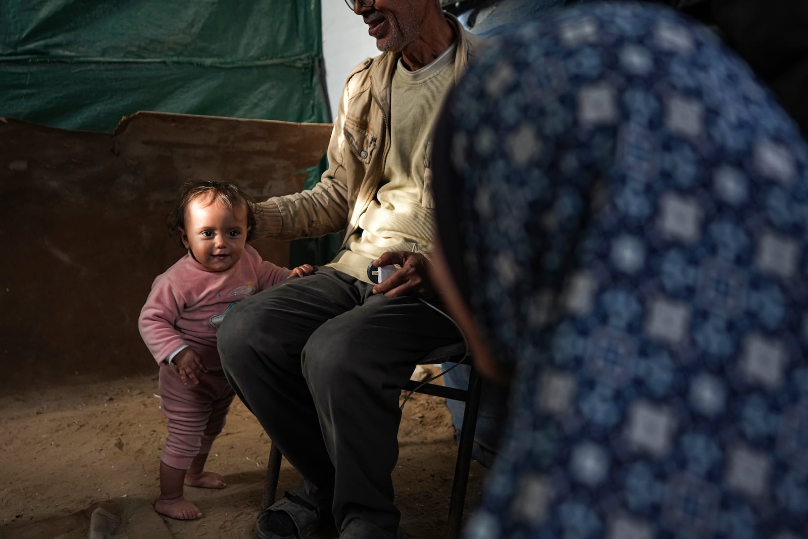 Massa Zaqout, a 15-month-old child, stands inside her family's tent at a camp for displaced Palestinians in Deir al-Balah, central Gaza Strip, Tuesday, Jan. 14, 2025. (AP Photo/Abdel Kareem Hana)