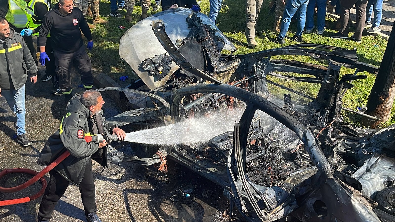 A Civil Defense firefighter hoses down a burned car that was hit by an Israeli drone strike, in the southern port city of Sidon, Lebanon, Monday, Feb. 17, 2025.(AP Photo)