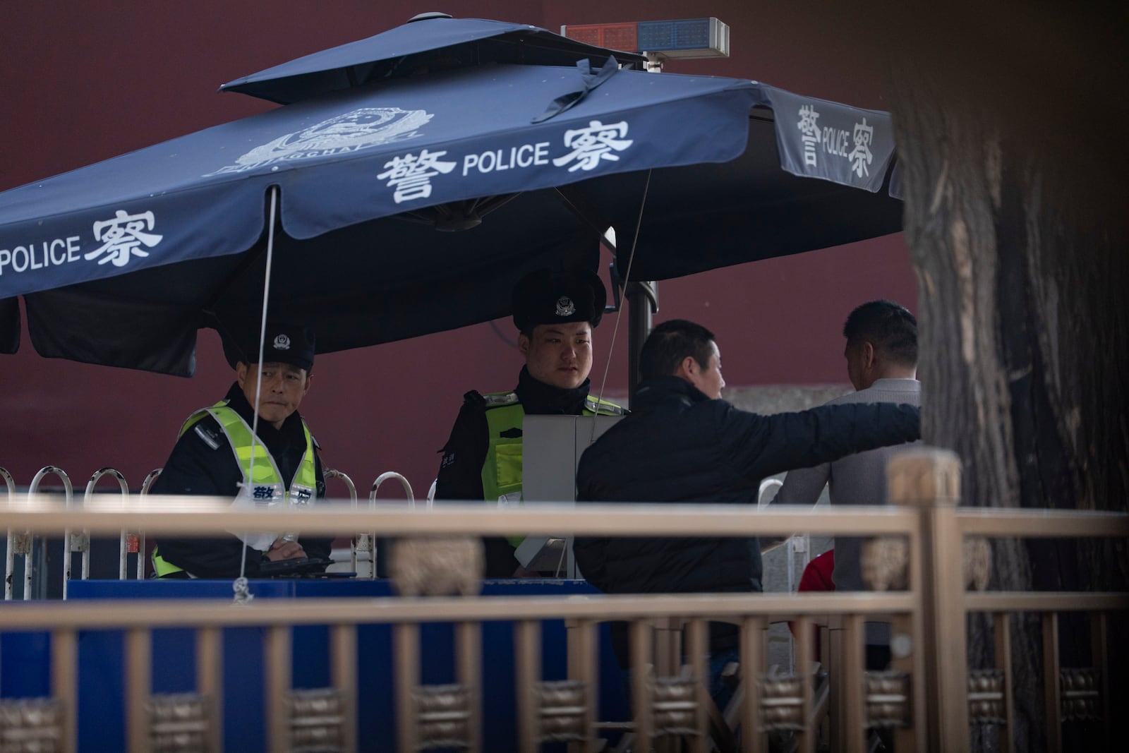 Chinese police officers check the identities of people near the Great Hall of the People ahead of the National People's Congress in Beijing, on Feb. 28, 2025. (AP Photo/Ng Han Guan)