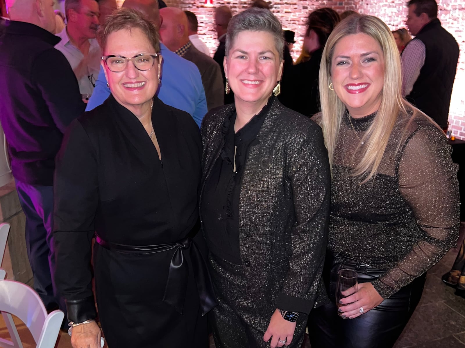 Emilee Ambrose, right, with mother (left), and sister (middle) at the Dayton Art Institute’s “Bourbon and Bubbles” event, November 2023. Ambrose's mother and both grandmothers are breast cancer survivors. Ambrose and her sister both opted for prophylactic double mastectomies because of their high risk for the disease.