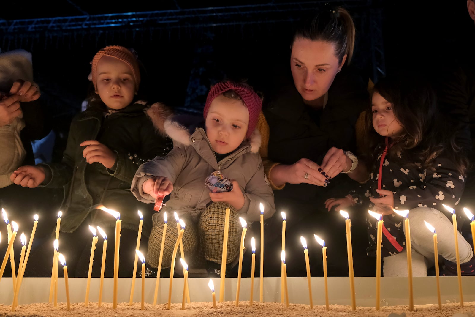 People light candles for the victims of the yesterdays, shooting rampage in Cetinje, in Podogrica, Montenegro, Thursday, Jan. 2, 2025. (AP Photo/Risto Bozovic)