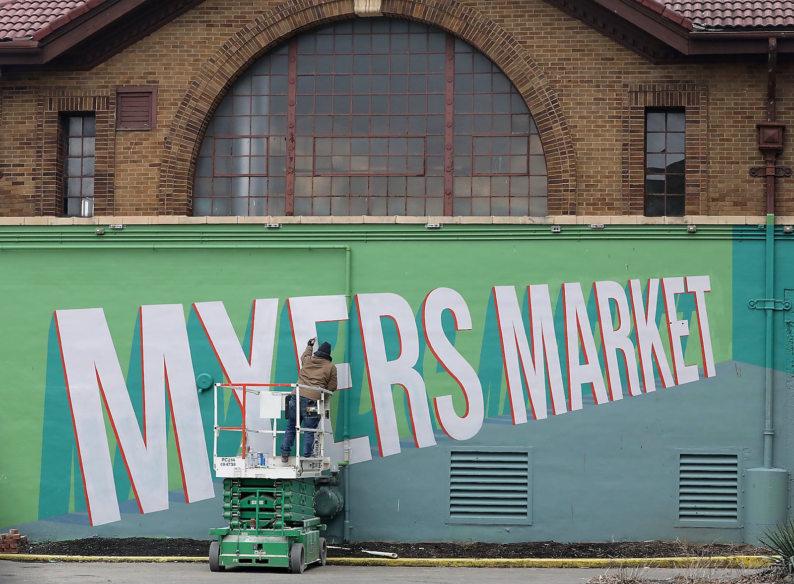 The new COhatch is looking to the future without forgetting the past as a worker paints a Myers Market mural on the back of the building. BILL LACKEY/STAFF