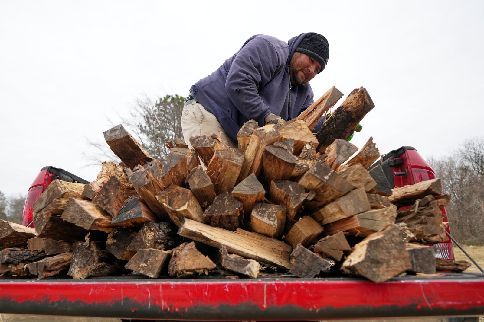 William Amaya sells firewood out of his pickup truck Monday, Jan. 20, 2025, in Houston, ahead of a winter storm predicted to dump several inches of snow in Southeast Texas. (AP Photo/David J. Phillip)