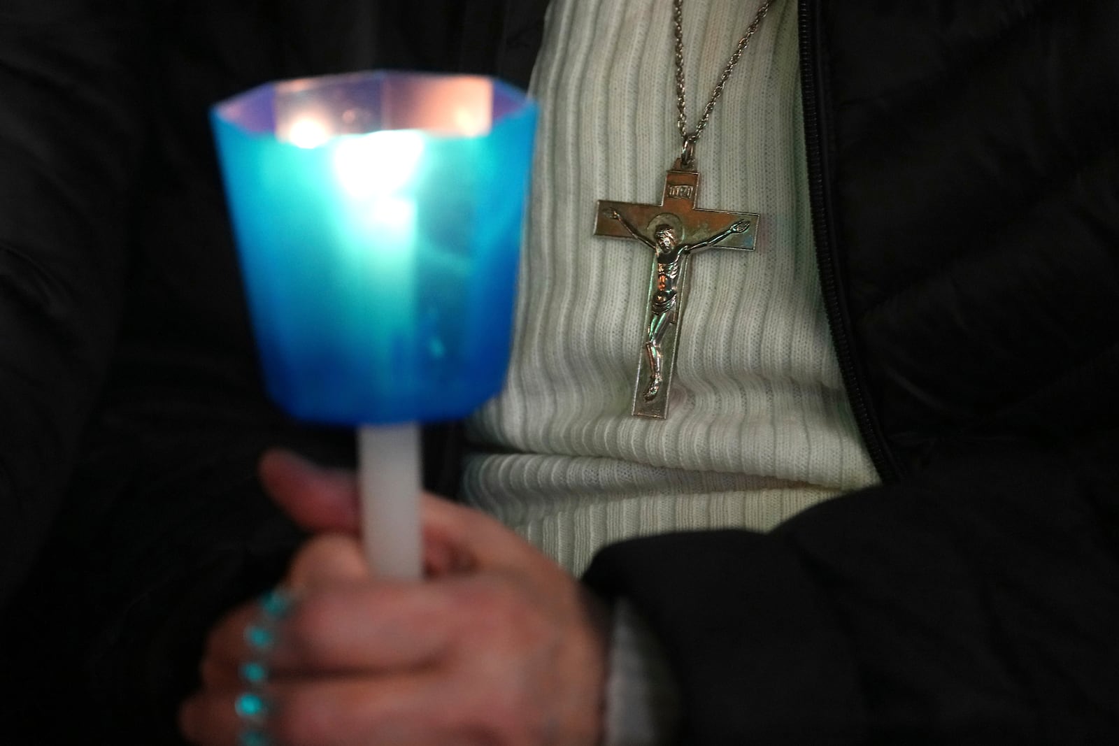 A woman holds a candle as she attends a rosary prayer with Cardinal Victor Manuel Fernandez held for the health of Pope Francis in St Peter's Square at The Vatican, Friday, Feb. 28, 2025. (AP Photo/Kirsty Wigglesworth)