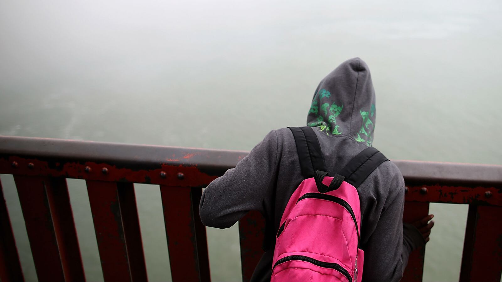 A visitor looks over the railing on the Golden Gate Bridge on June 27, 2014 in San Francisco, California. As of August 2018, nearly 1,700 people had leapt to their deaths from the bridge since it's creation in 1937.