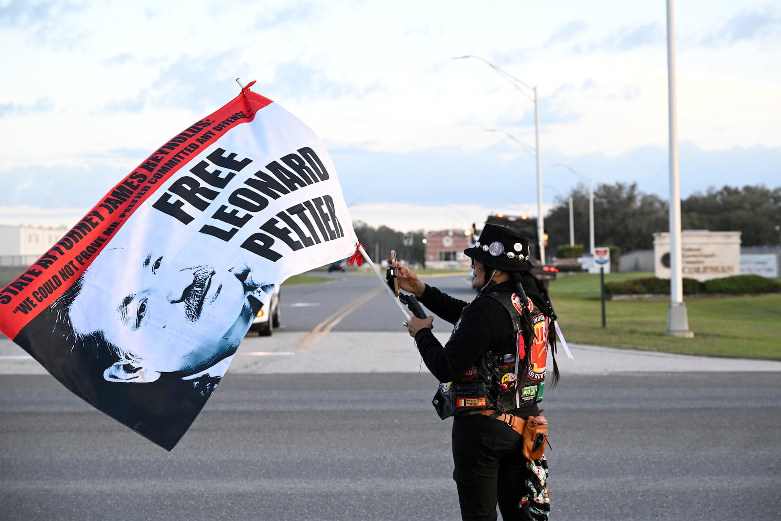 Tracker Gina Marie Rangel Quinones stands in front of Federal Correctional Complex, Coleman, while awaiting the release Leonard Peltier, Tuesday, Feb. 18, 2025, in Sumterville, Fla. (AP Photo/Phelan M. Ebenhack)