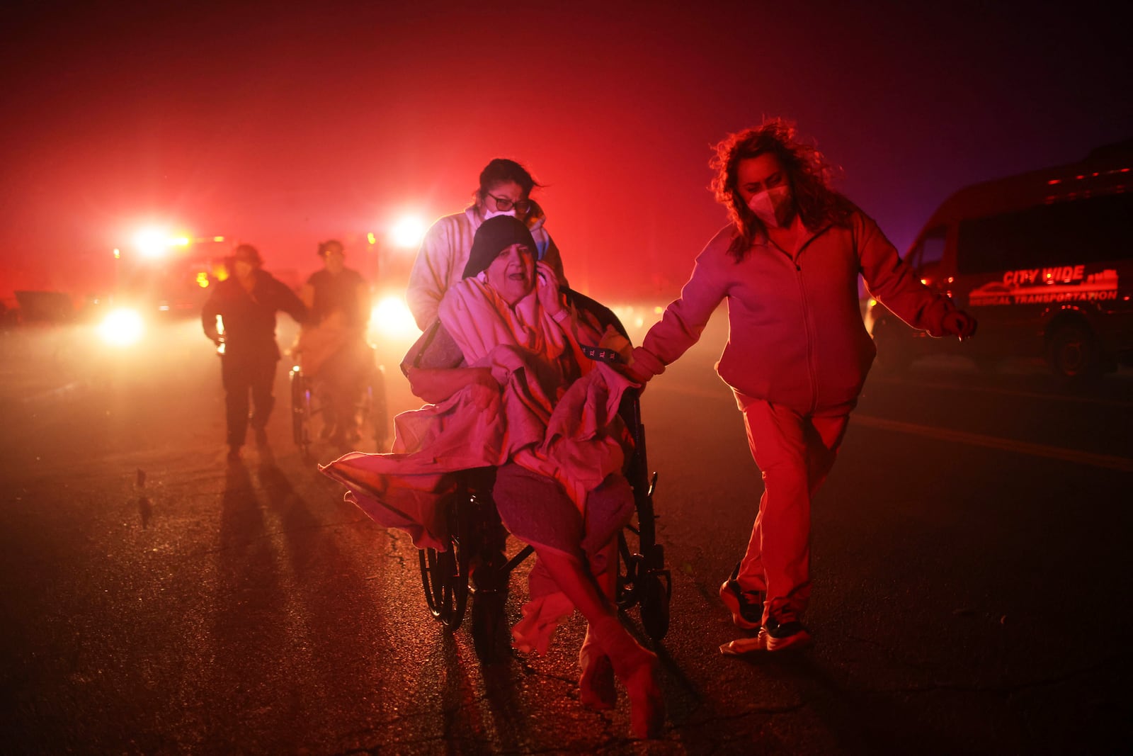 Residents of a senior center are evacuated as the Eaton Fire approaches Tuesday, Jan. 7, 2025 in Altadena, Calif. (AP Photo/Ethan Swope)