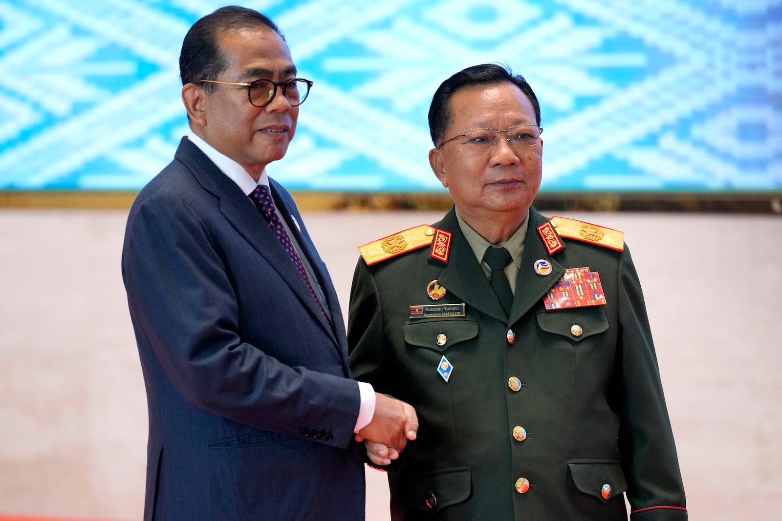 Laos' Defense Minister Chansamone Chanyalath, right, greets Malaysian Defence Minister Mohamed Khaled Nordin during the Association of Southeast Asian Nations (ASEAN) defense ministers' meeting in Vientiane, Laos, Wednesday, Nov. 20, 2024. (AP Photo/Anupam Nath)