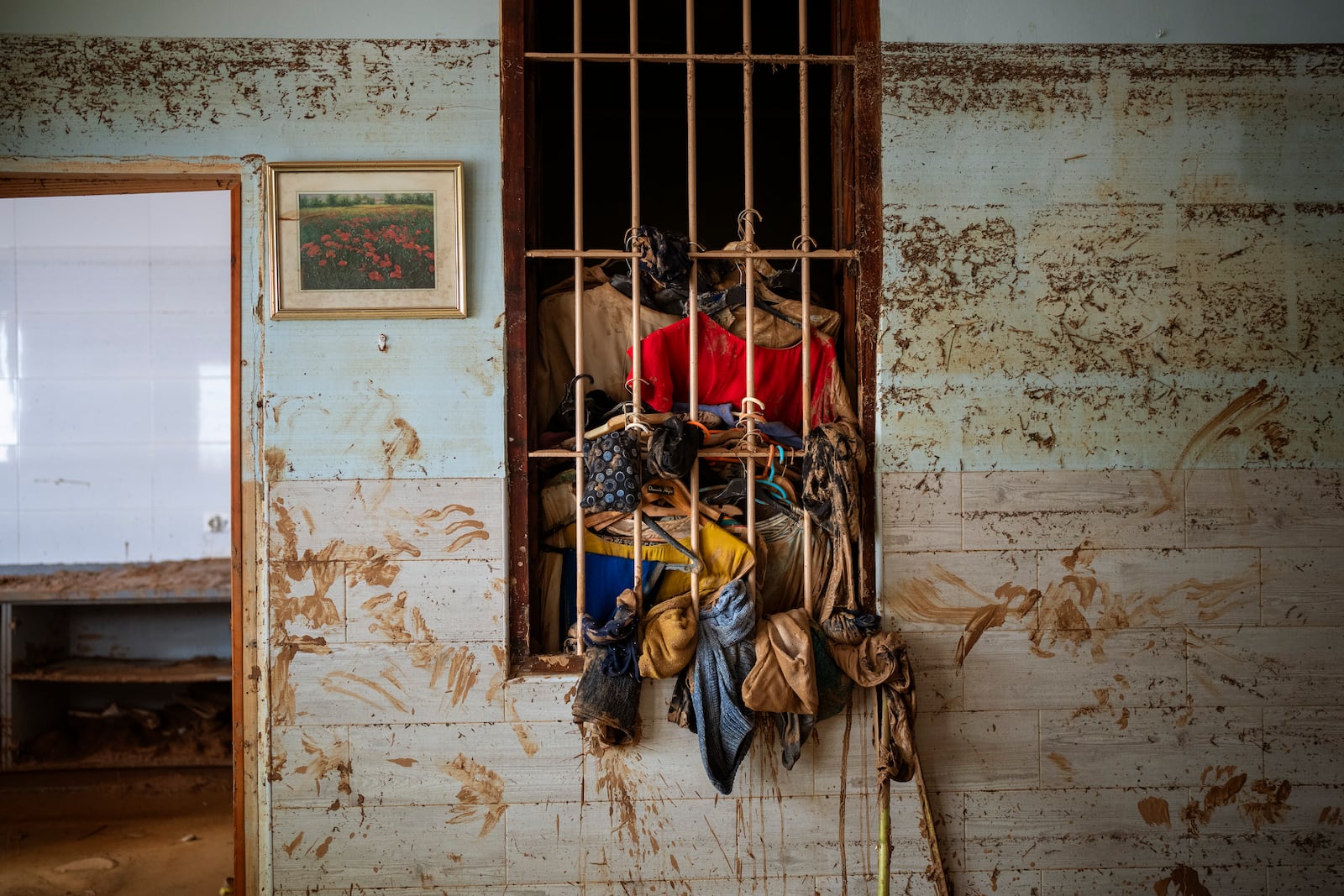 Wet clothes hangs on a window near the water level marker in an area affected by floods in Paiporta, Valencia, Spain, Tuesday, Nov. 5, 2024. (AP Photo/Emilio Morenatti)