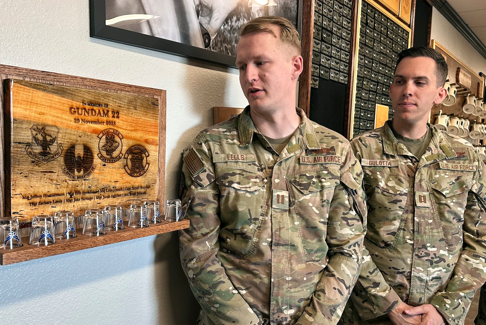 Osprey pilots Capt. Christian Eells, left, and Capt. Matthew Gulotta stand Oct. 8, 2024, at Cannon Air Force Base, N.M., beside a memorial to the Air Force Special Operations Command Osprey callsign "Gundam 22" that crashed off the coast of Japan in November 2023, killing all eight service members aboard. (AP Photo/Tara Copp)