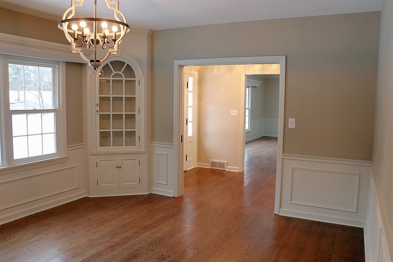 Pocket doors open into the formal dining room, which has two built-in, corner cupboards that have keystone arched glass cabinet doors.