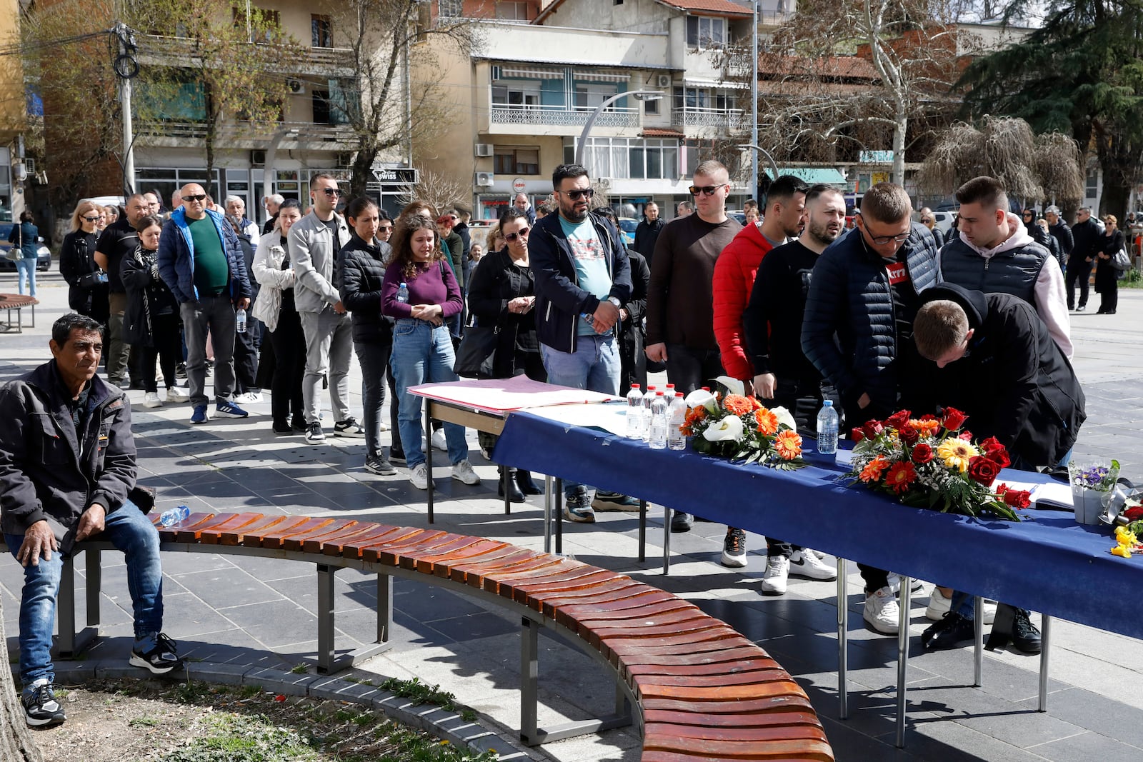 People wait in line to write condolence messages for the victims of a massive nightclub fire in the town of Kocani, North Macedonia, Monday, March 17, 2025. (AP Photo/Boris Grdanoski)