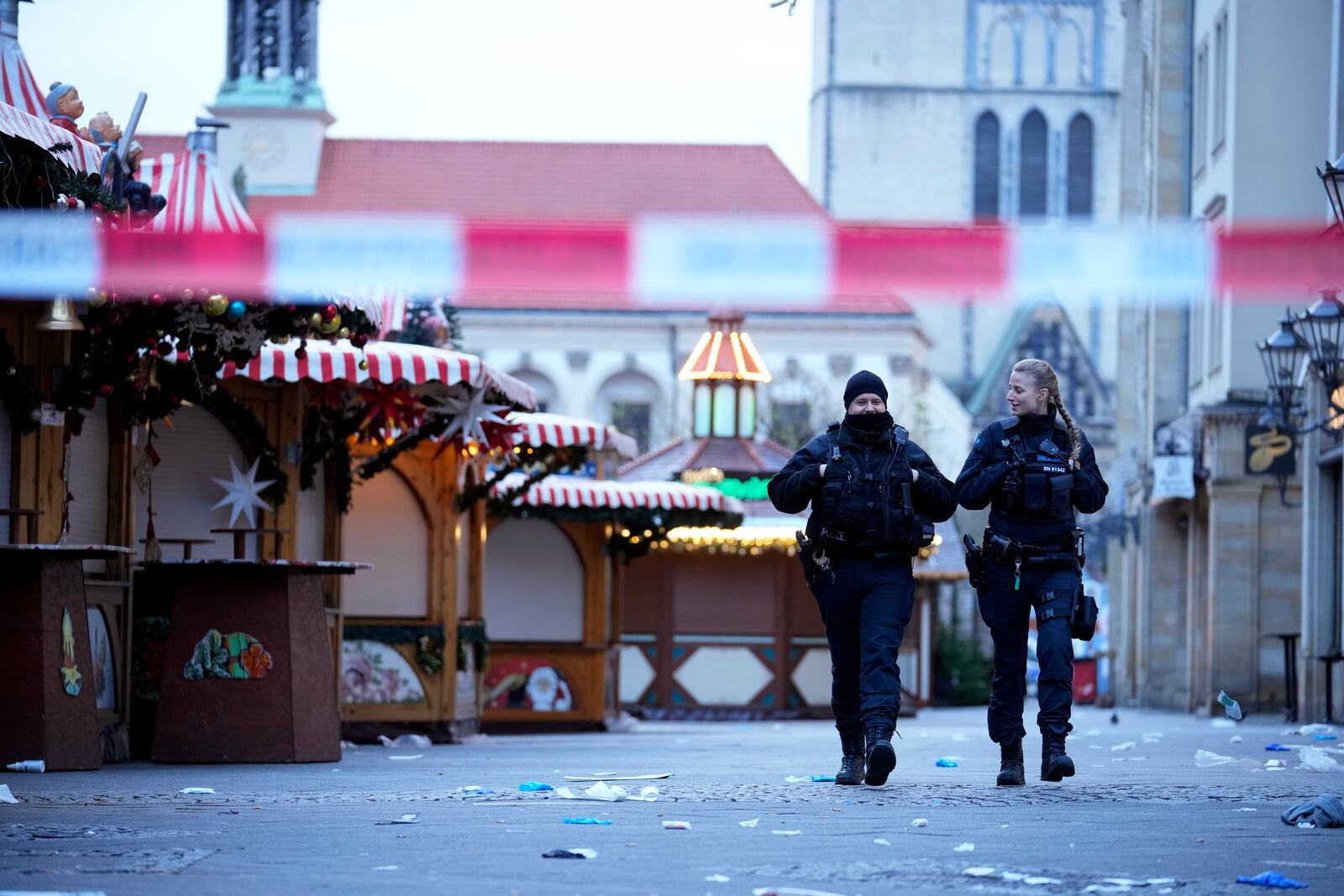 Police officers patrol a cordoned-off area at a Christmas Market, where a car drove into a crowd on Friday evening, in Magdeburg, Germany, Saturday, Dec. 21, 2024. (AP Photo/Ebrahim Noroozi)