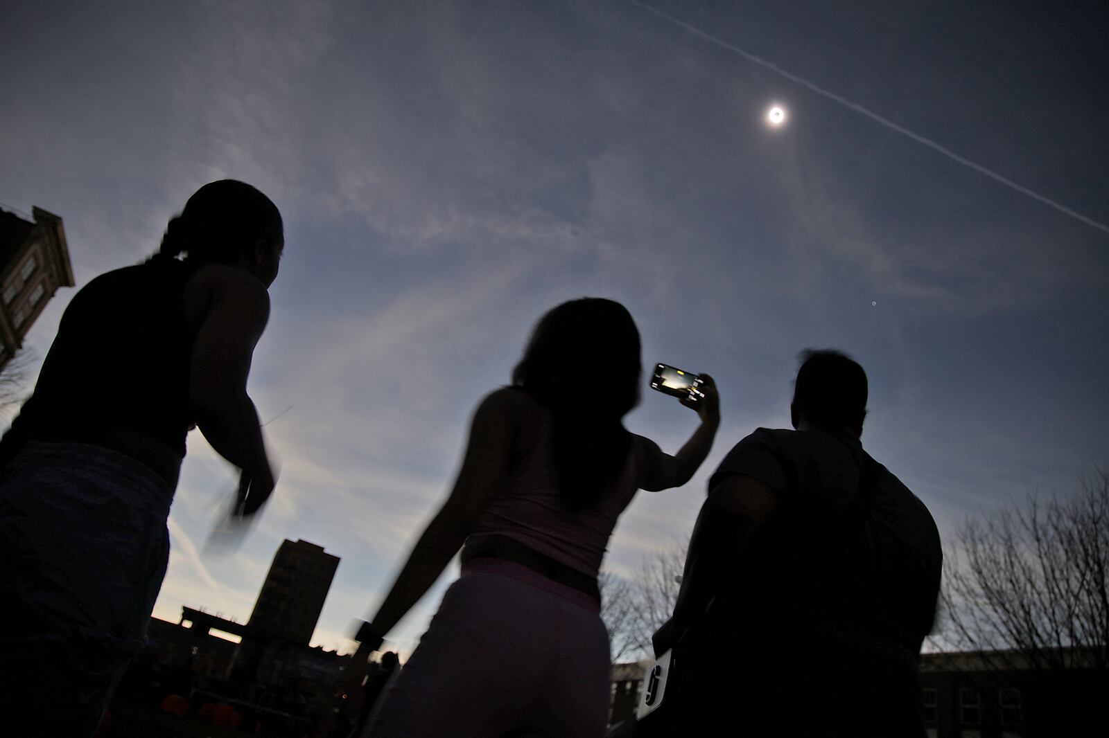 The crowd at National Road Commons Park is shrouded in darkness during the total eclipse Monday, April 8, 2024. BILL LACKEY/STAFF