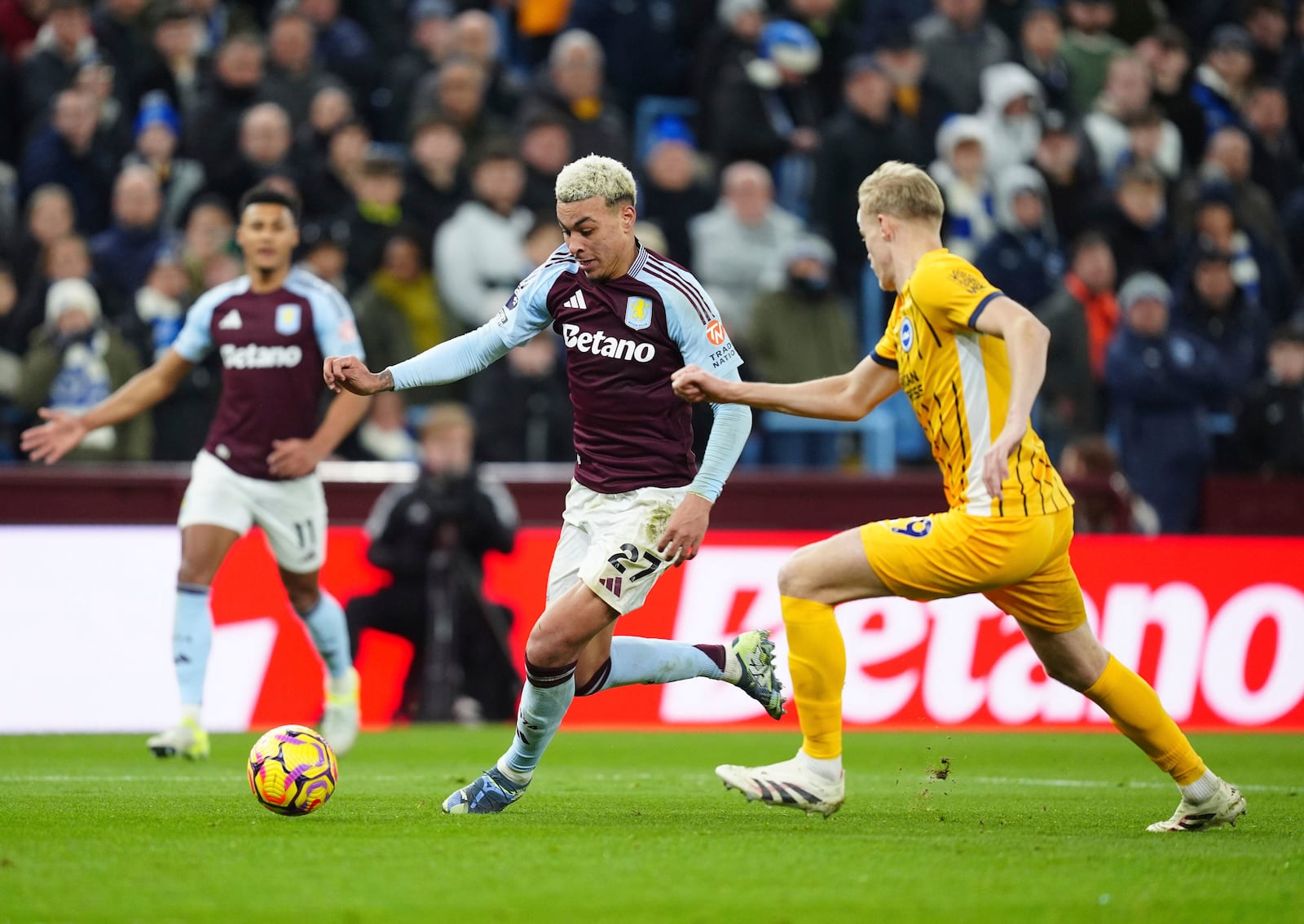 Aston Villa's Morgan Rogers and Brighton and Hove Albion's Jan Paul van Hecke, right, battle for the ball during the English Premier League soccer match between Aston Villa and Brighton and Hove Albion at Villa Park, Birmingham, England, Monday Dec. 30, 2024. (David Davies/PA via AP)