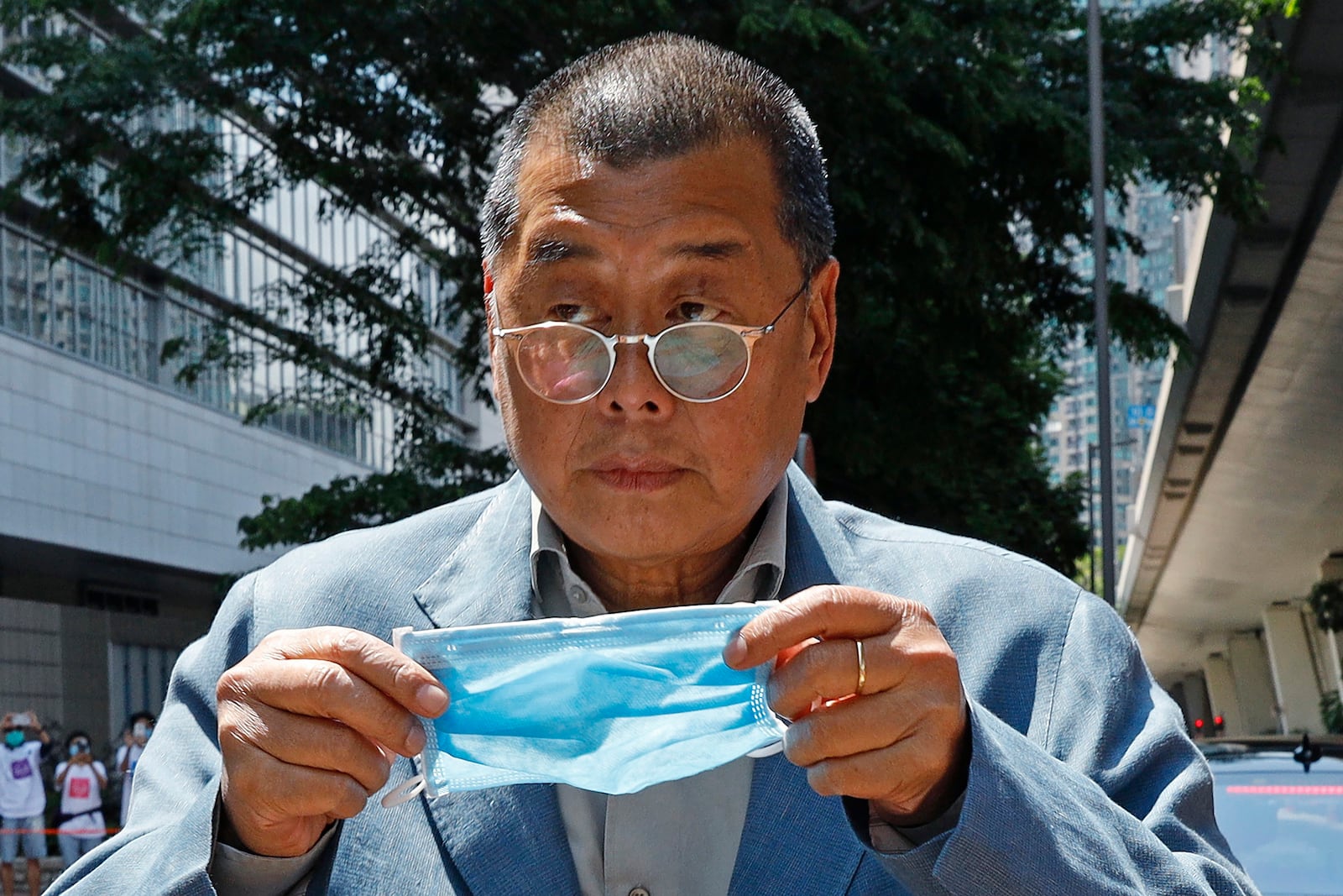 Hong Kong media tycoon Jimmy Lai, who founded local newspaper Apple Daily, is about to wear a face mask before entering a court in Hong Kong on May 5, 2020. (AP Photo/Kin Cheung, File)