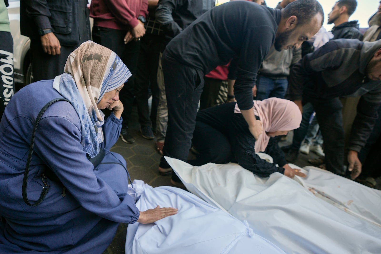 Women mourn over the bodies of victims from an Israeli army airstrike outside a hospital in Deir al-Balah, Gaza, Sunday Nov. 17, 2024. Palestinian medical officials reported Sunday that Israeli strikes overnight killed 12 people in Central Gaza. One child and five women were counted among them.(AP Photo/Abdel Kareem Hana)