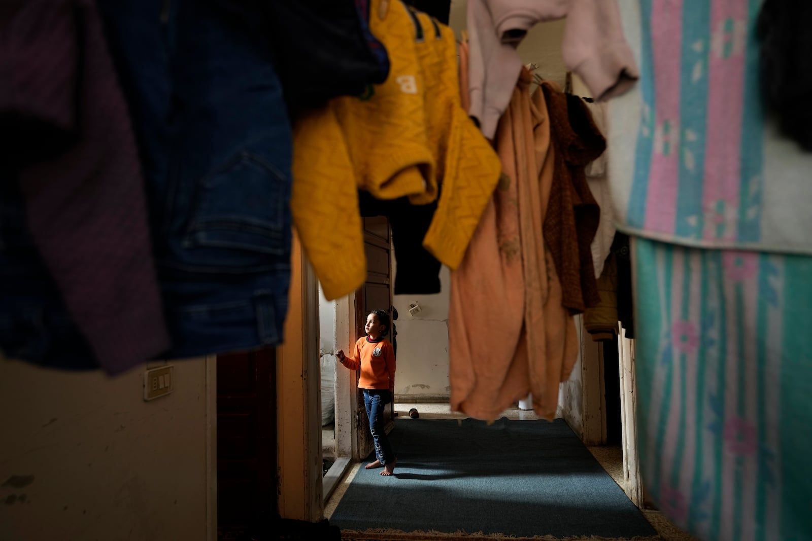 A girl stands at the entrance of her family house who survived from the sarin struck during a 2013 chemical weapons attack that was blamed on then President Bashar Assad's forces, in Zamalka neighbourhood, on the outskirts of Damascus, Syria, Wednesday, Dec. 25, 2024. (AP Photo/Hussein Malla)