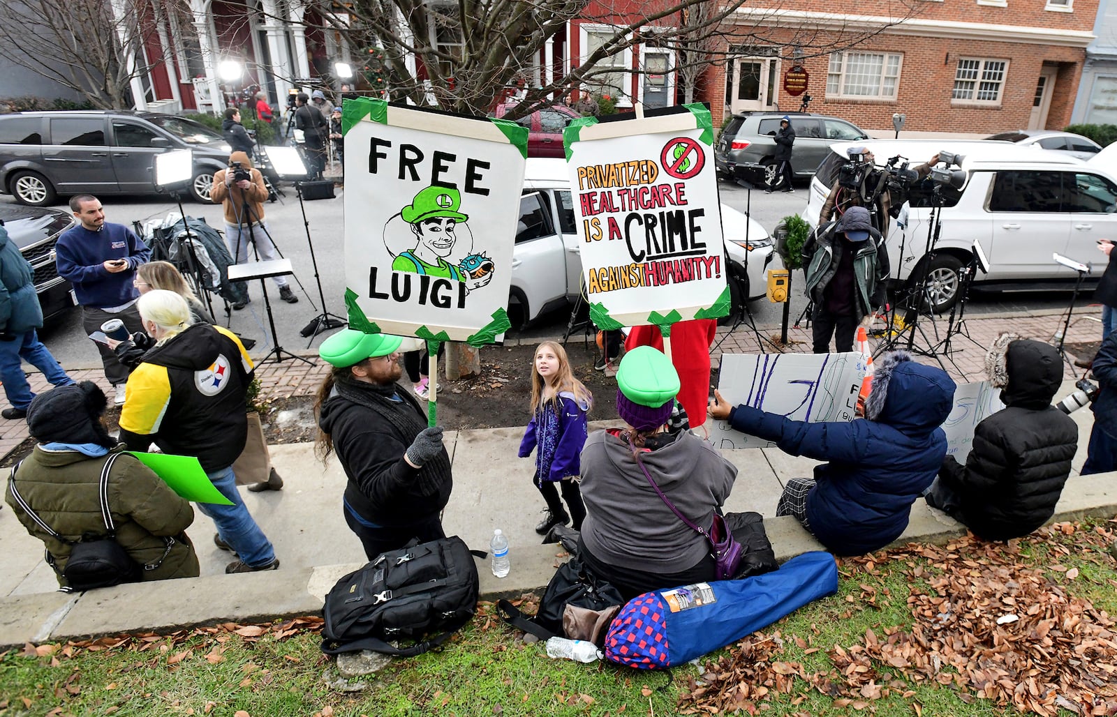 Supporters of Luigi Nicholas Mangione, who is being charged with the murder of UnitedHealthcare CEO Brian Thompson, gather at the front of Blair County Courthouse for the suspect's preliminary and extradition hearing in Hollidaysburg, Pa., Thursday, Dec. 19, 2024. (Thomas Slusser/The Tribune-Democrat via AP)