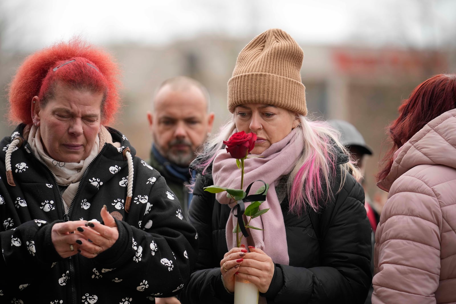 Citizens pay tribute and cry for deaths outside St. John's Church near a Christmas Market, where a car drove into a crowd on Friday evening, in Magdeburg, Germany, Saturday, Dec. 21, 2024. (AP Photo/Ebrahim Noorozi)