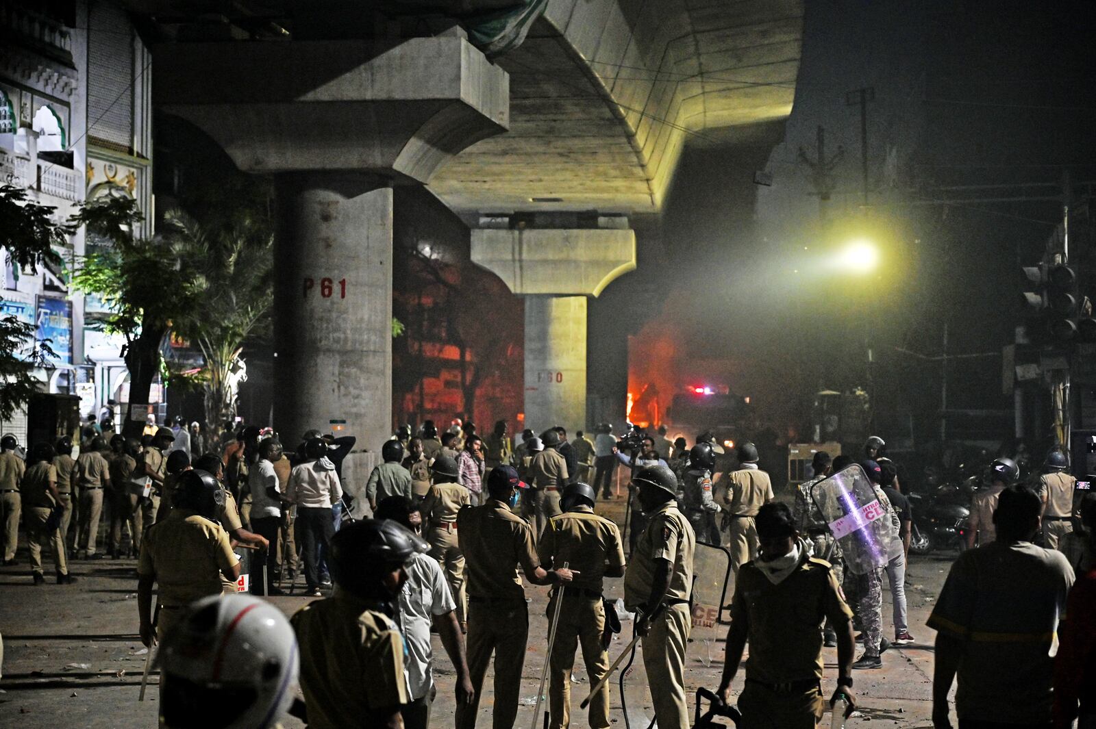 Policemen watch as vehicles are torched during communal clashes sparked by protests demanding removal of the tomb of 17th-century Muslim Mughal ruler Aurangzeb in Nagpur, India, Monday, March 17, 2025. (AP Photo)