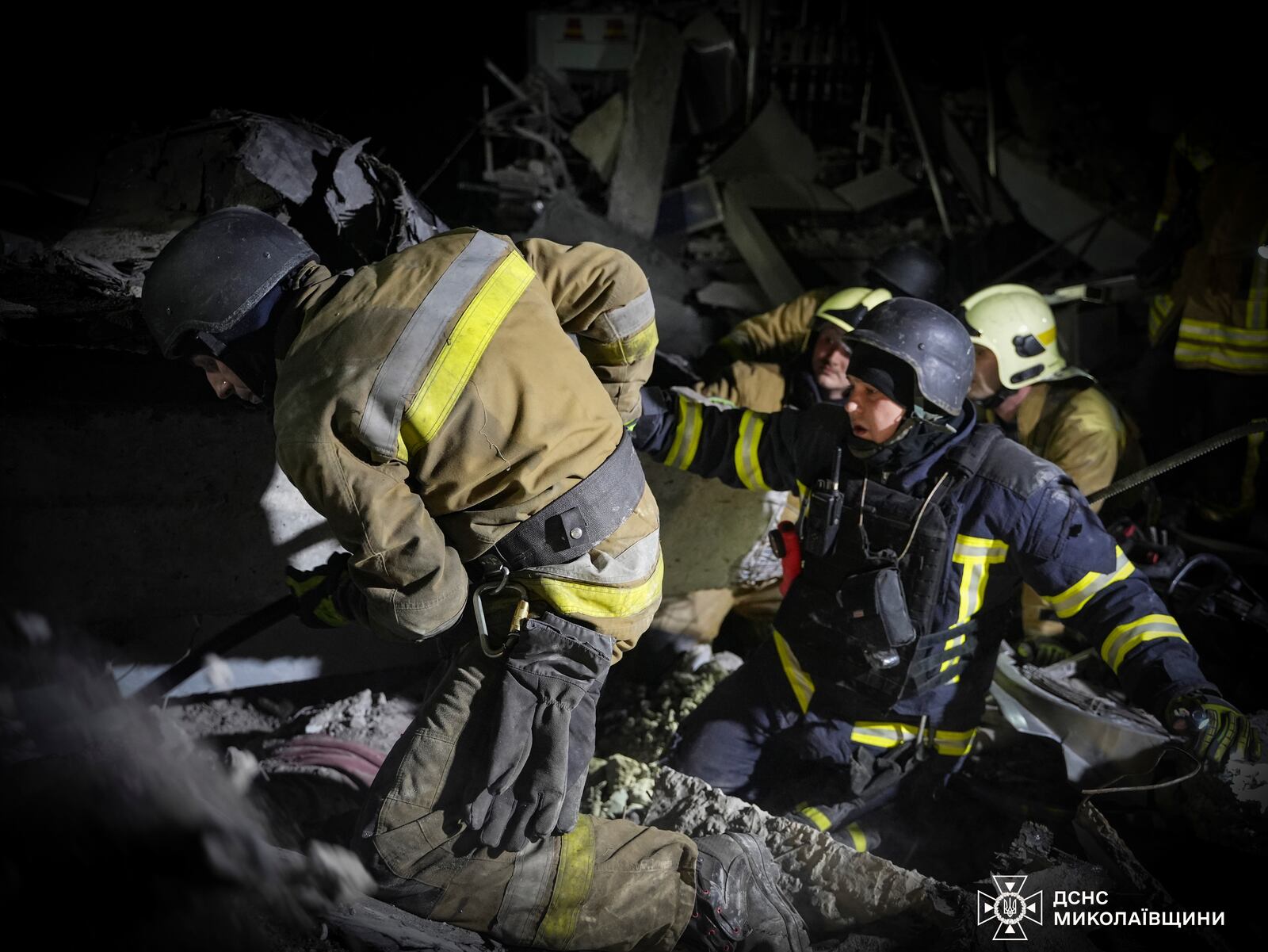 In this photo provided by the Ukrainian Emergency Service, rescuers unblock the body of a civilian who was killed when a Russian drone hit a city food factory in Mykolaiv, Ukraine, Wednesday, Jan. 29, 2025. (Ukrainian Emergency Service via AP)