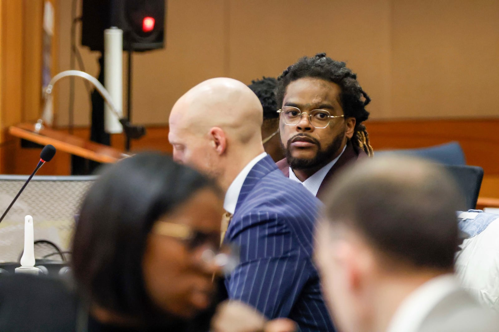 Shannon Stillwell, center back, sits with his attorney, Max Schardt, left, as he looks at the prosecutors during the Young Thug trial at Fulton County Courthouse in Atlanta on Tuesday, Nov. 26, 2024. (Miguel Martinez/Atlanta Journal-Constitution via AP)