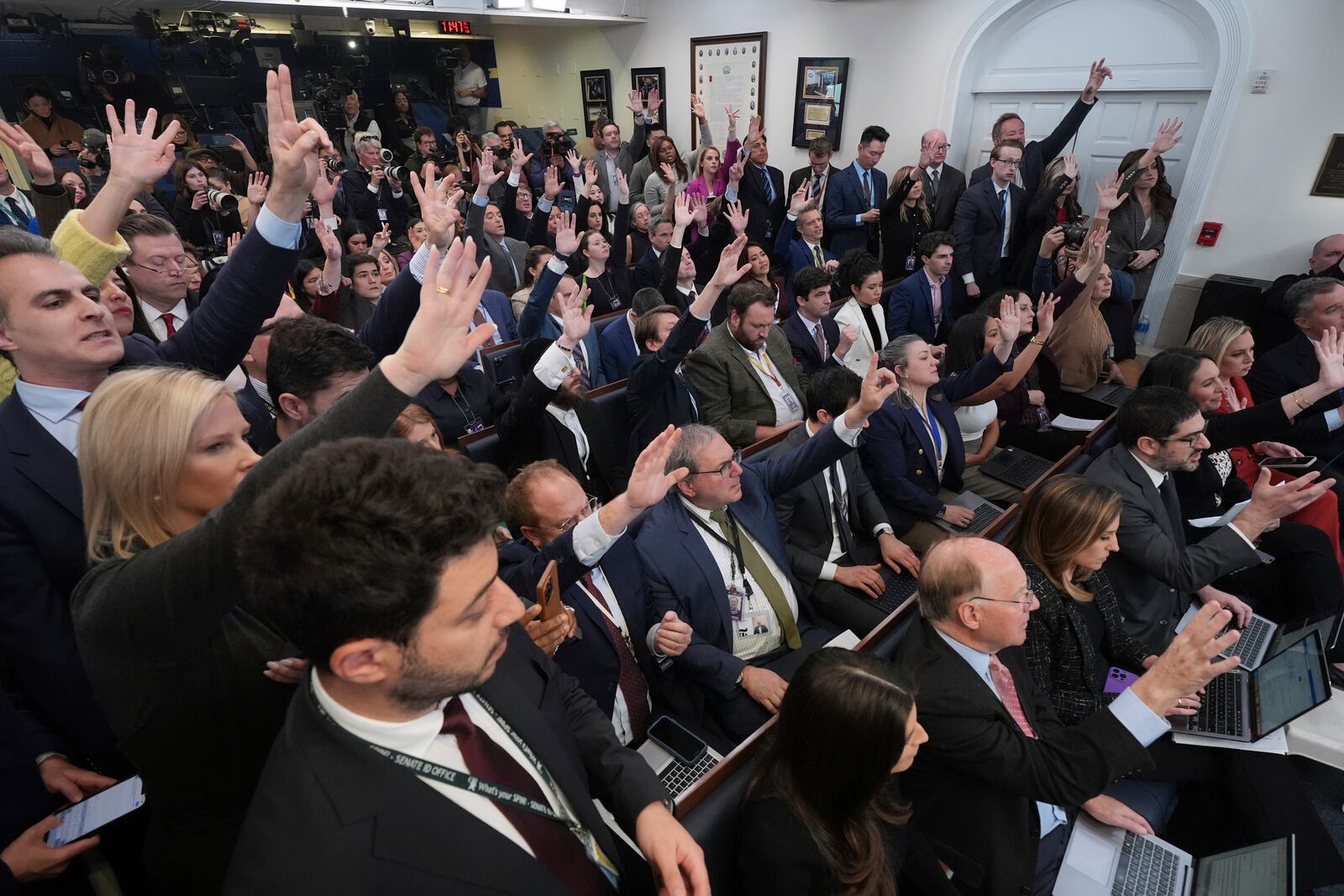 Reporters raise their hands to be called on by President Donald Trump as he speaks with reporters in the James Brady Press Briefing Room at the White House, Thursday, Jan. 30, 2025, in Washington. (AP Photo/Jacquelyn Martin)