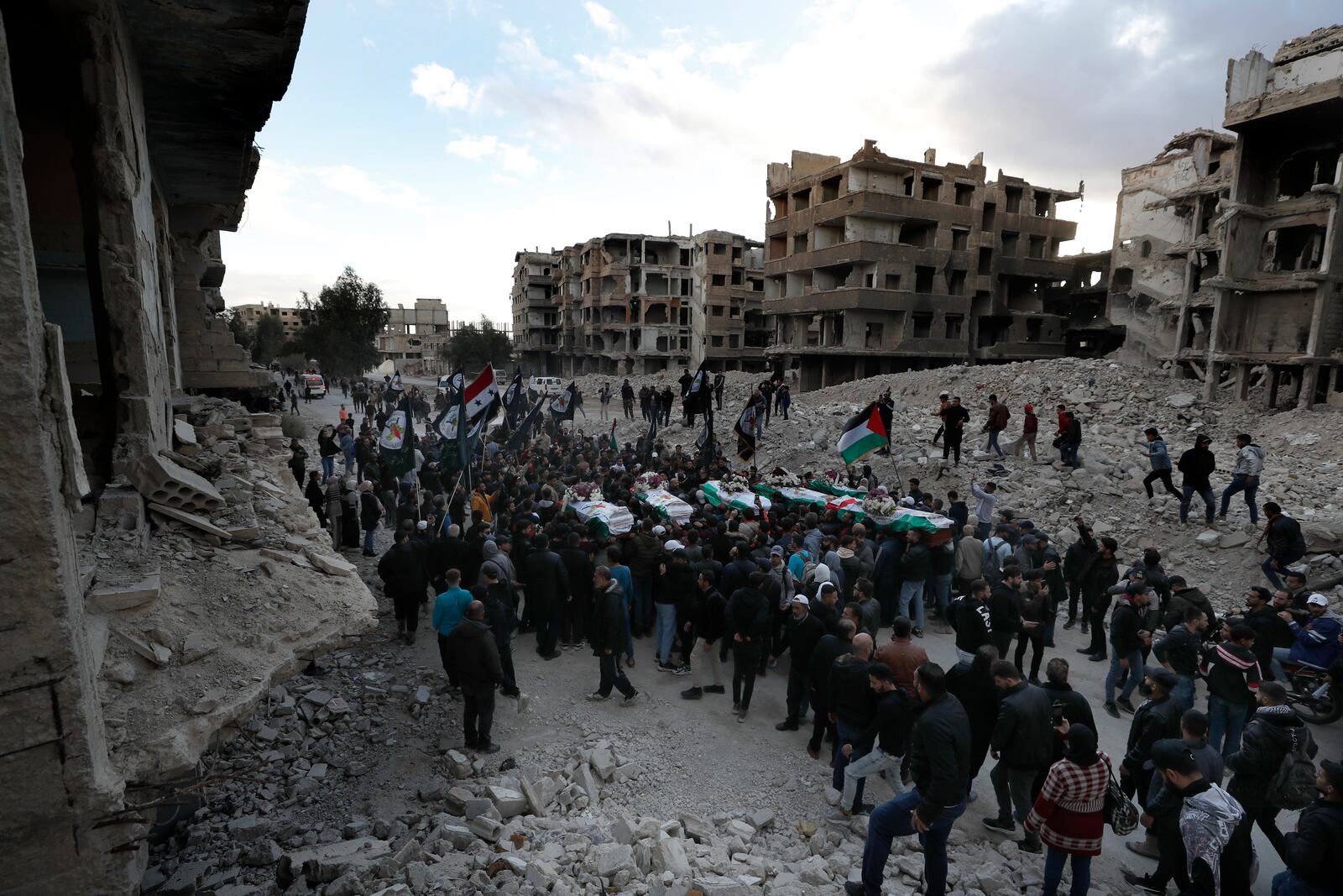 Mourners carry the coffins of the members of the Palestinian militant group Islamic Jihad who were killed last week in an Israeli airstrike, during their funeral procession at the Palestinian refugee camp of Yarmouk, in Damascus, Syria, Monday, Nov. 18, 2024. (AP Photo/Omar Sanadiki)