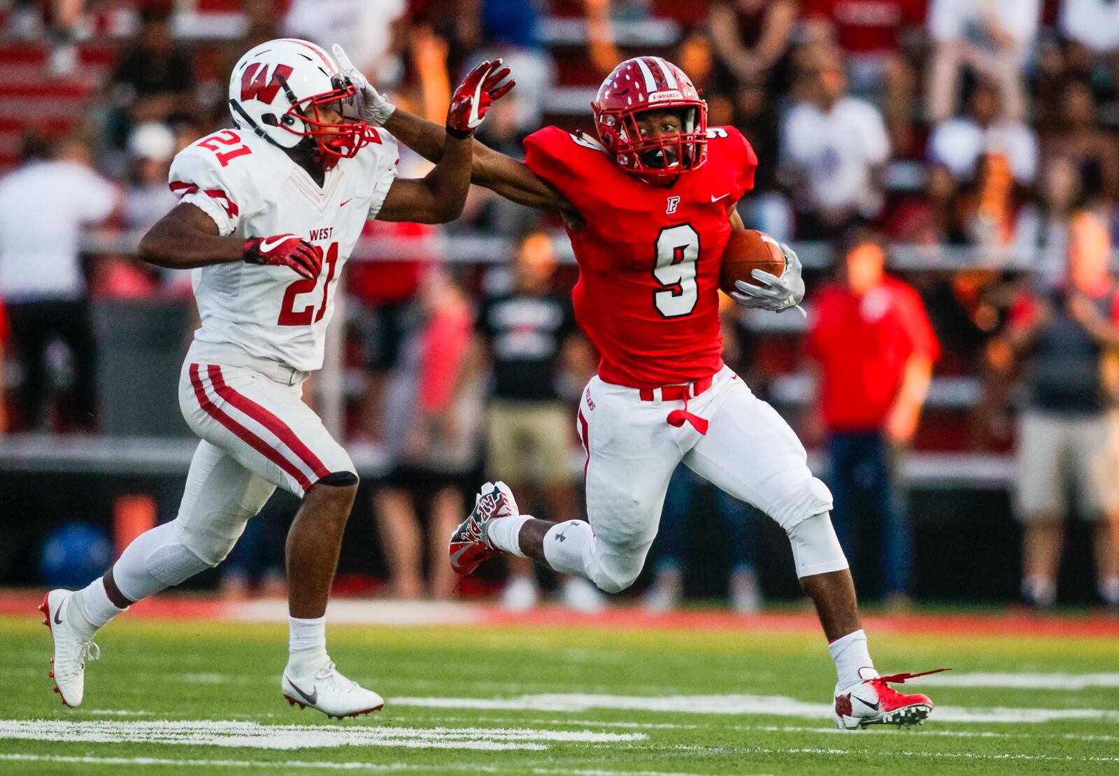 Fairfield's Jutahn McClain stiff arms Lakota West's Hunter Anderson II as he carries the football during their game Friday, Sept. 14 at Fairfield Stadium. Fairfield won 37-3. NICK GRAHAM/STAFF