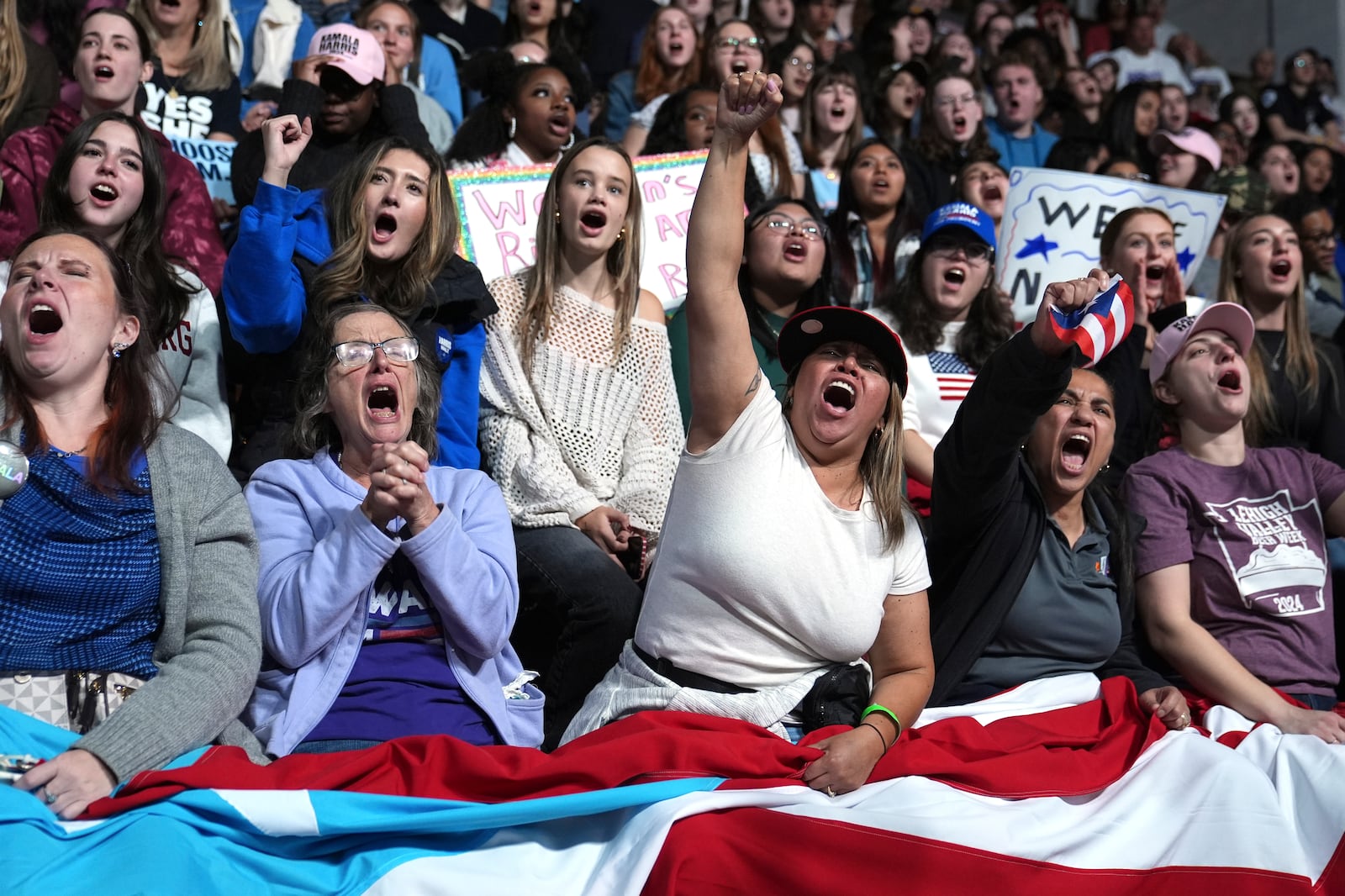 Attendees holding the flag of Puerto Rico cheer as Allentown, Pa. Mayor Matt Tuerk speaks during a campaign rally for Democratic presidential nominee Vice President Kamala Harris in Memorial Hall at Muhlenberg College in Allentown, Pa., Monday, Nov. 4, 2024. (AP Photo/Susan Walsh)