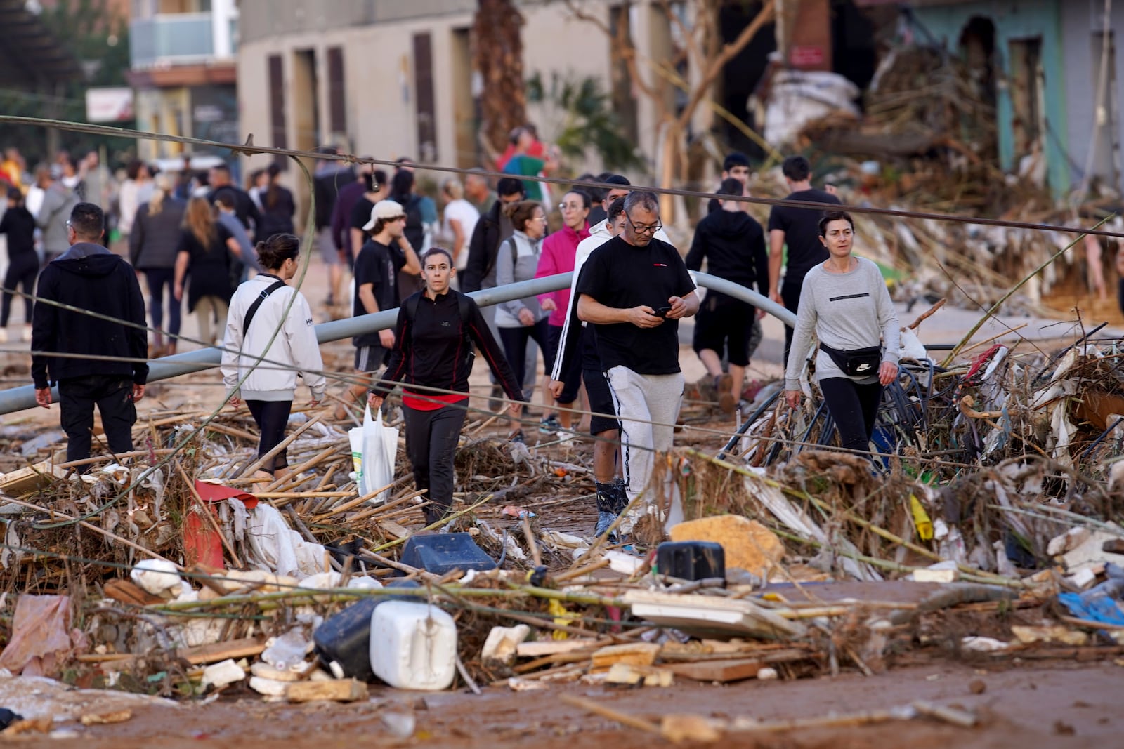 Residents walk in a street after flooding in Paiporta, near Valencia, Spain, Wednesday, Oct. 30, 2024. (AP Photo/Alberto Saiz)